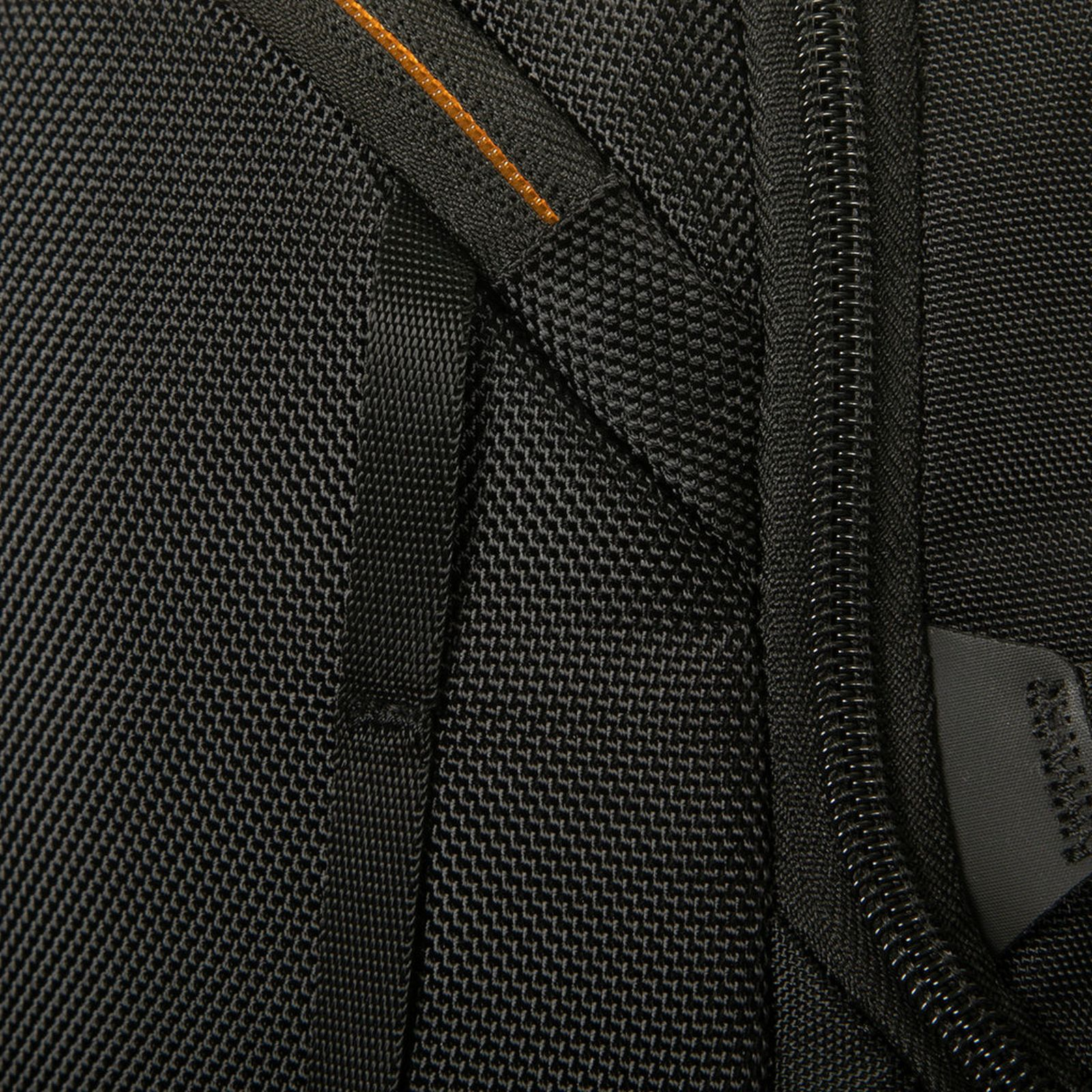 Nahaufnahme eines schwarzen, strukturierten Rucksackstoffs mit Reißverschluss und orangefarbenen Nähten.