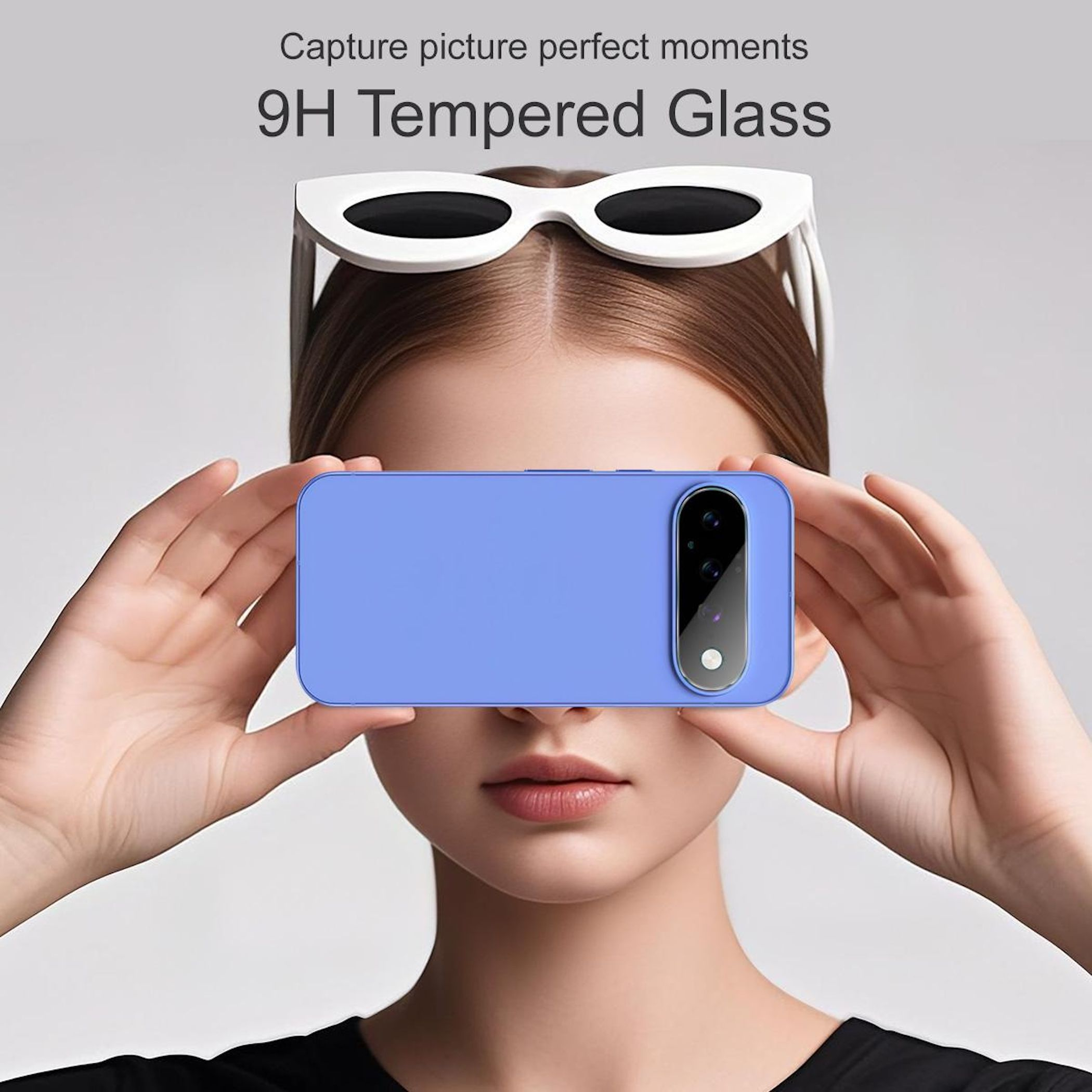 Eine Frau hält ein blaues Smartphone vor ihr Gesicht. Auf ihrem Kopf trägt sie eine weiße Sonnenbrille.