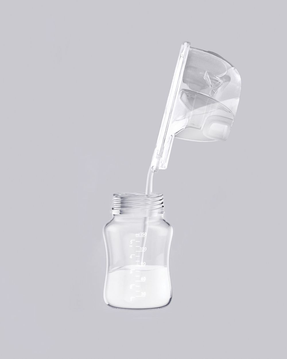 Milch gießt aus einem Pumpenteil in eine Babyflasche vor grauem Hintergrund.