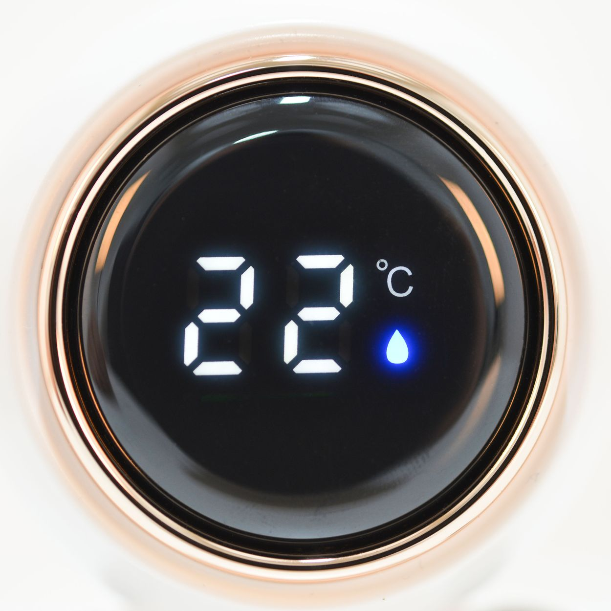 Ein runder digitaler Bildschirm mit der weißen Anzeige 22 Grad Celsius und einem blauen Wassertropfen.