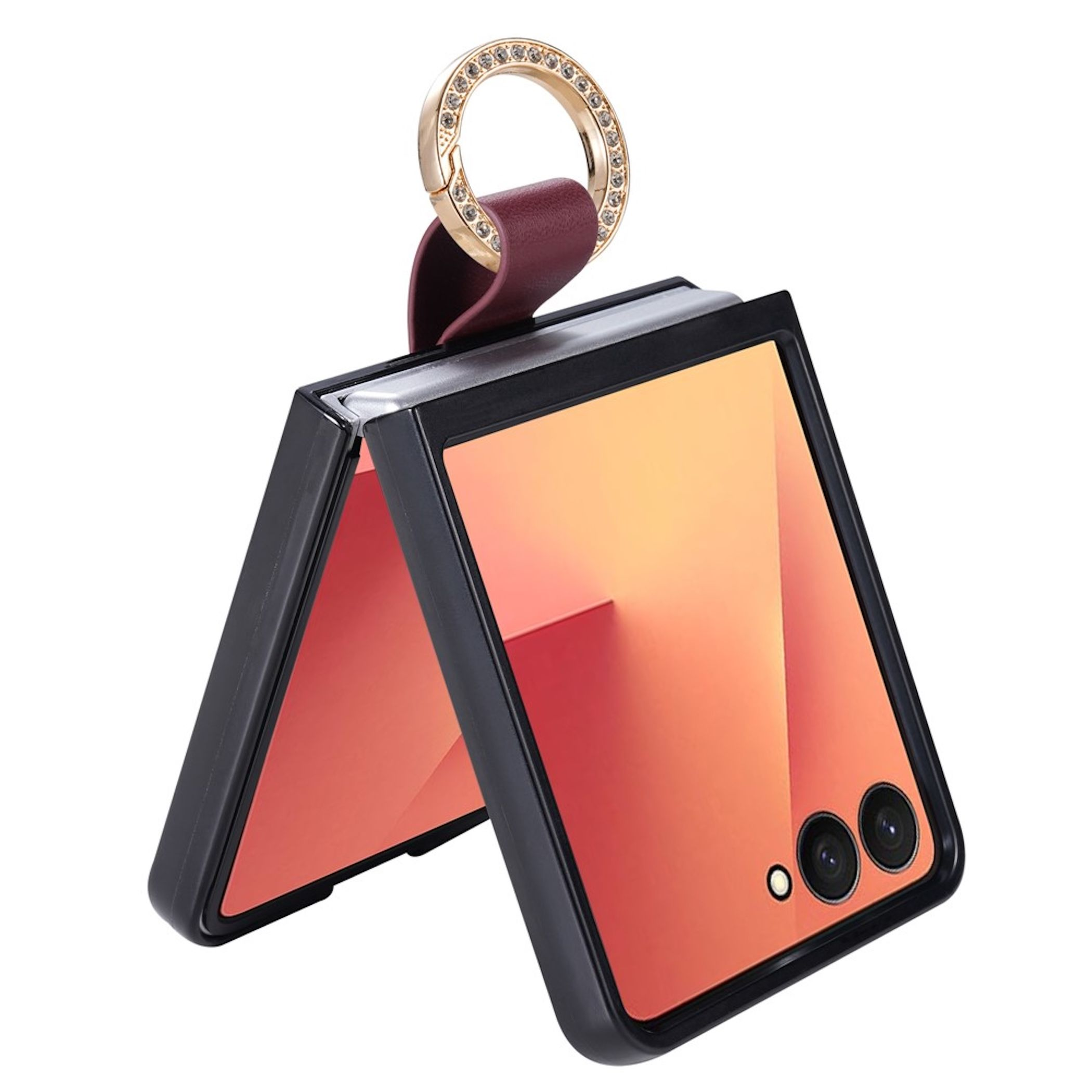 Klapptelefon in schwarzer Hülle mit burgunderrotem Lederriemen und glitzerndem goldenen Ring auf weißem Grund.