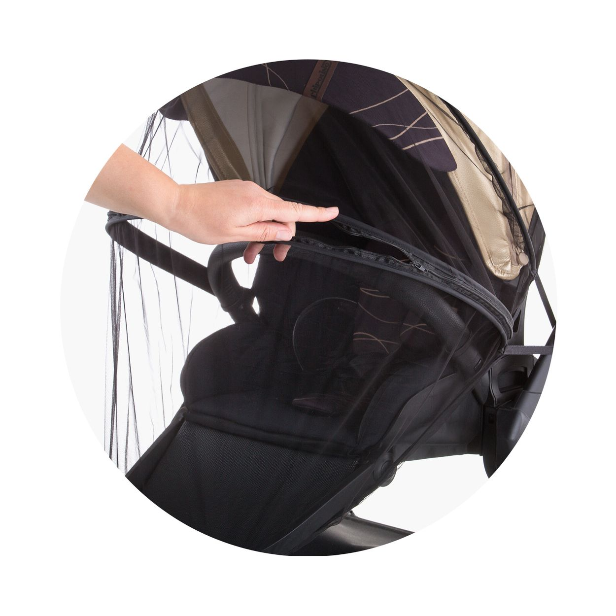 Eine Hand schließt den Reißverschluss eines Moskitonetzes an einem schwarzen Kinderwagen.