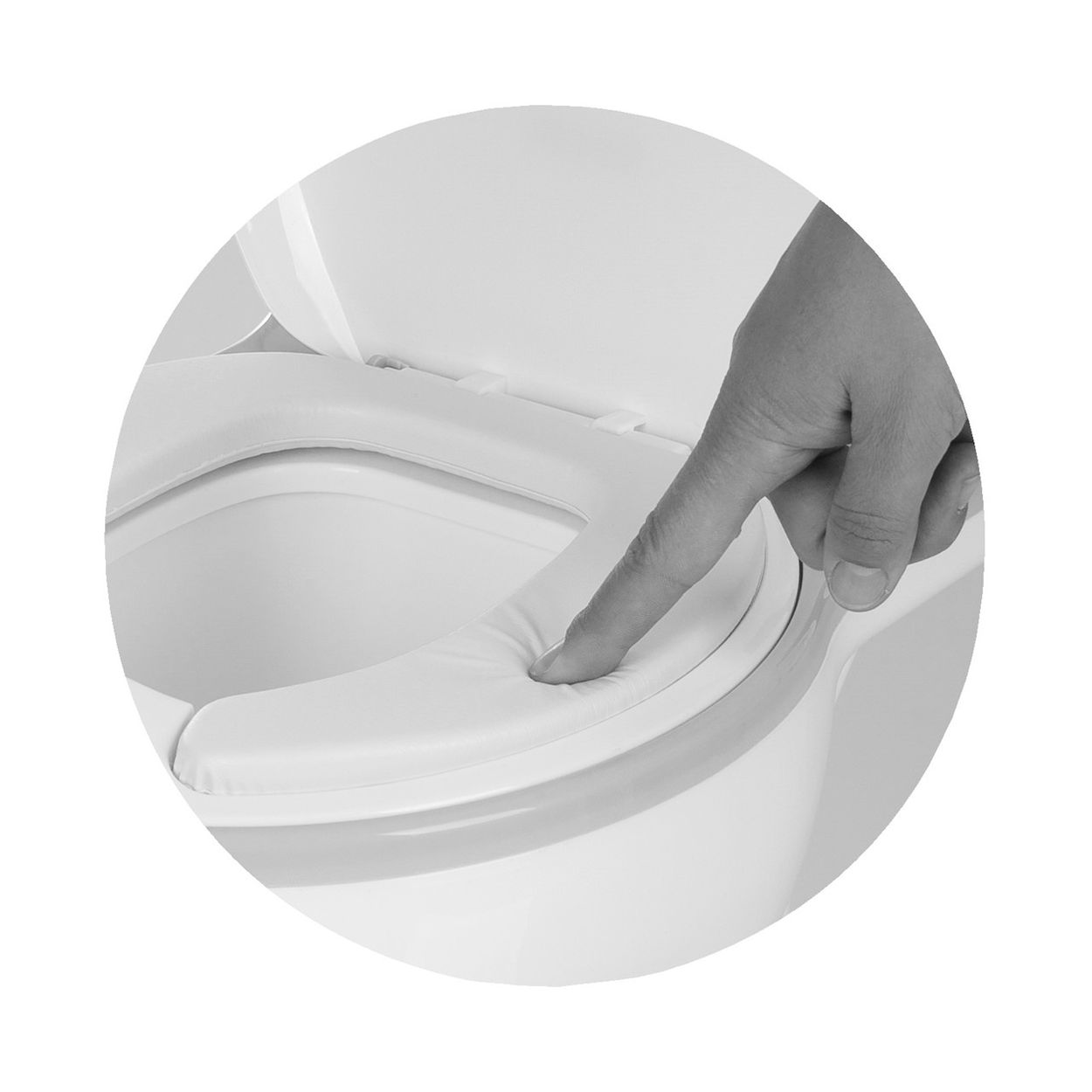 Ein Finger drückt auf einen weichen, gepolsterten Toilettensitz.