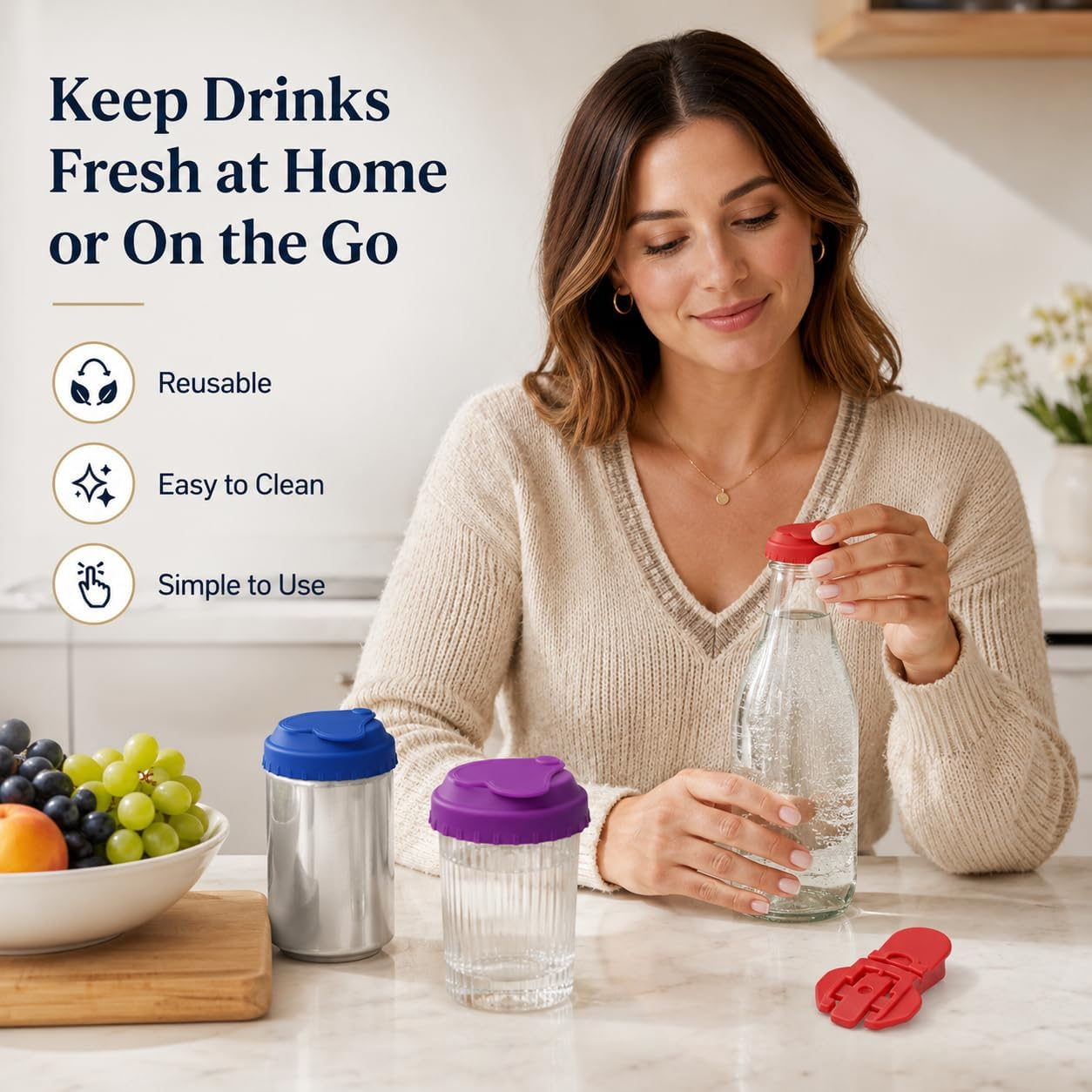 Eine Frau hält eine mit Wasser gefüllte Glasflasche neben Bechern auf einer Theke mit Obst.