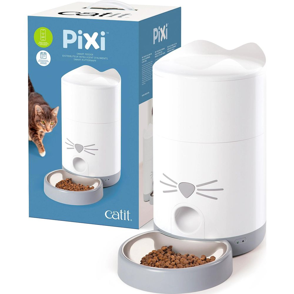Weißer Katzenfutterautomat mit Katzengesicht-Design und gefülltem Futternapf, daneben die bedruckte Verpackung.