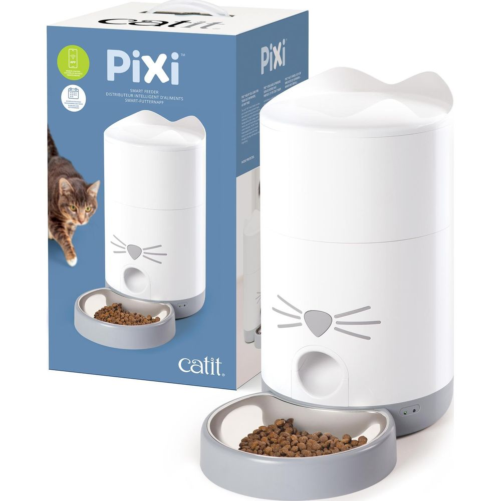 Ein weißer Catit Pixi Smart-Katzenfutterautomat mit Katzengesicht-Design und Futterschüssel steht neben der Box.