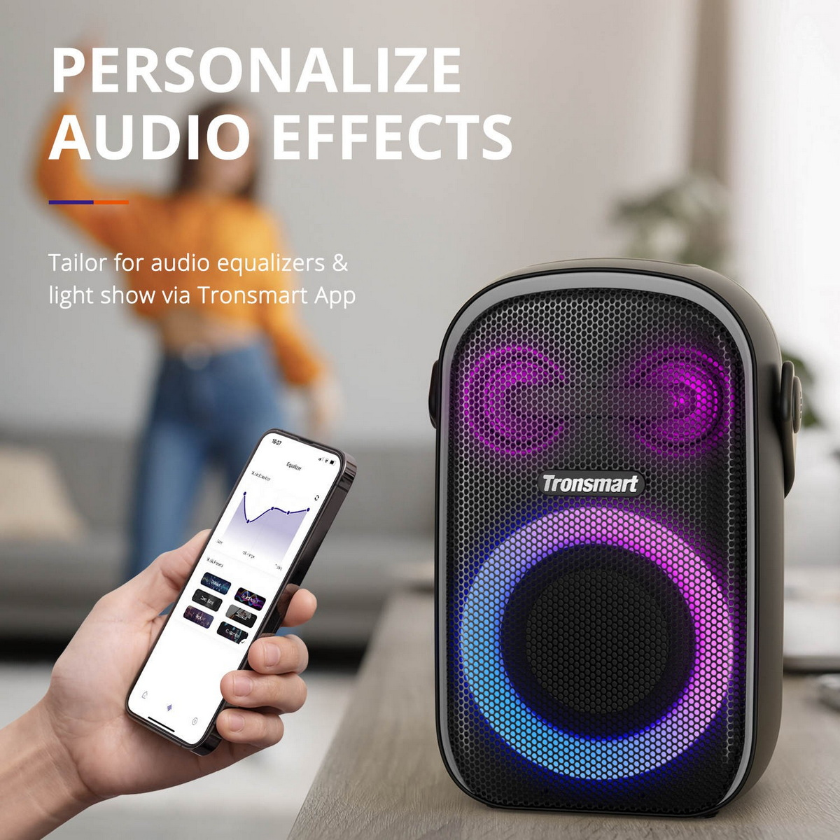 Hand hält Smartphone mit App-Equalizer neben einem beleuchteten Tronsmart Bluetooth-Lautsprecher.