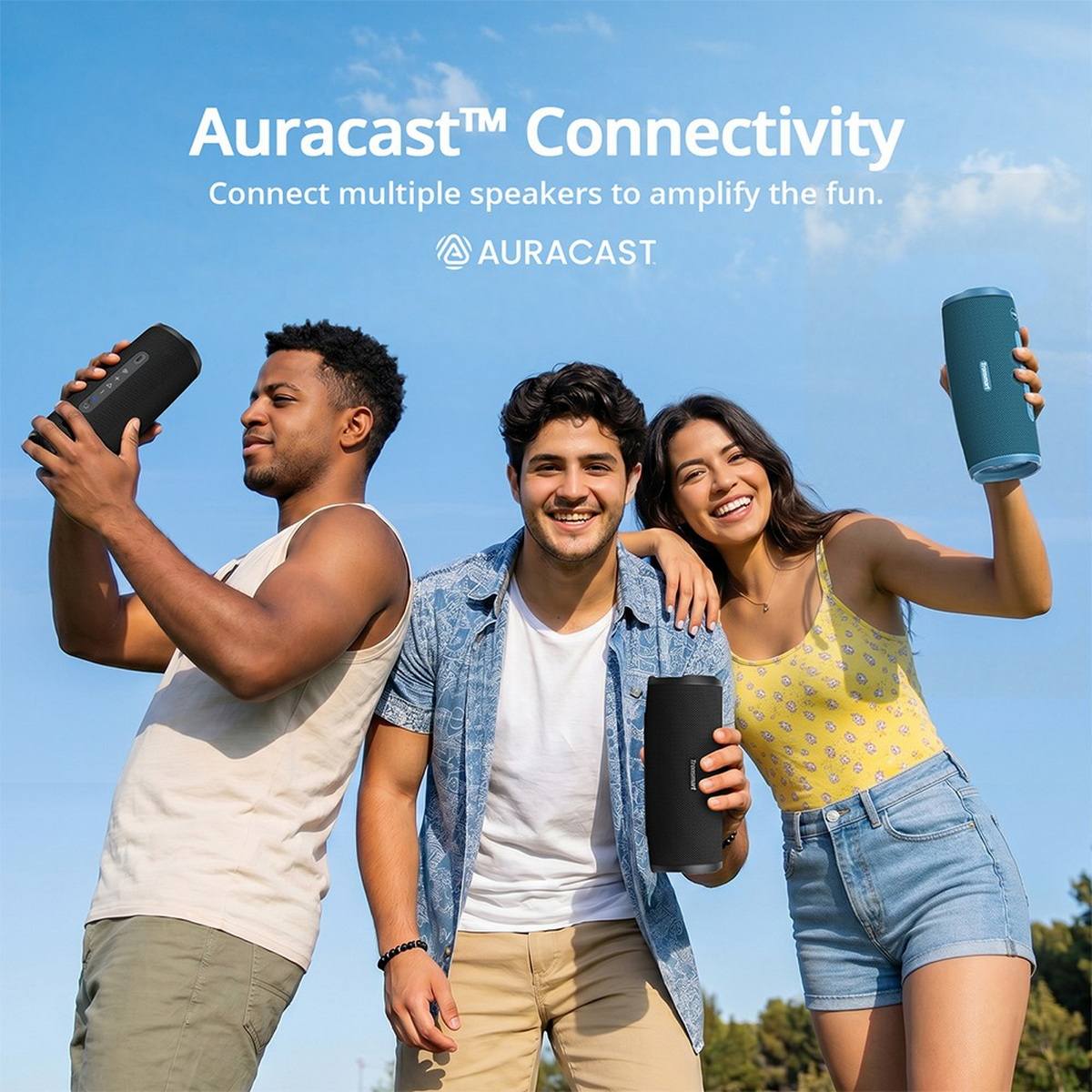 Drei glückliche Freunde halten draußen unter blauem Himmel tragbare Bluetooth-Lautsprecher.