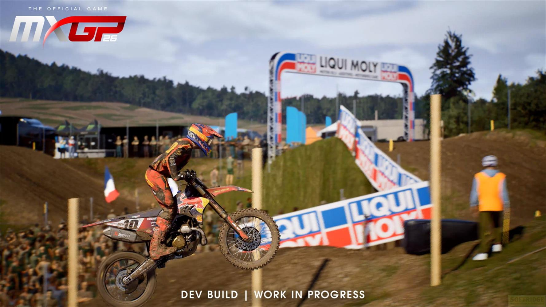 Ein Motocross-Fahrer springt mit einem Motorrad auf einer Schotterstrecke vor einer Zuschauermenge.