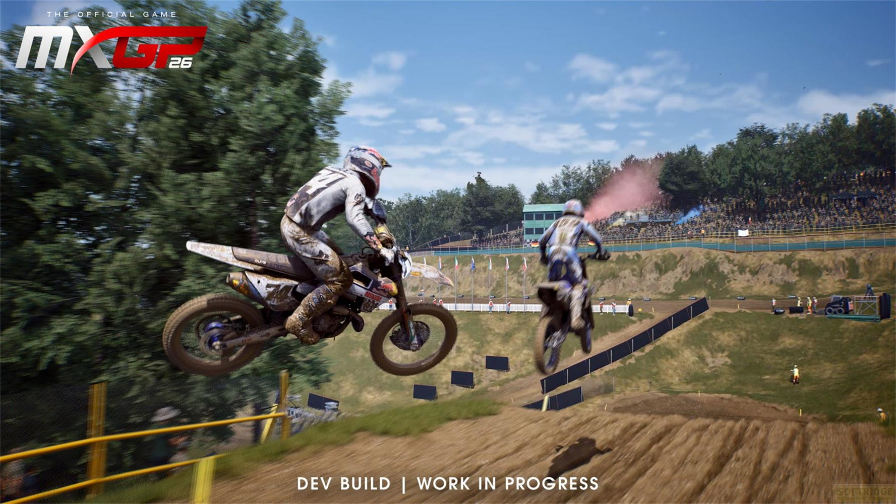 Zwei Motocross-Fahrer springen auf einer Rennstrecke über eine Schanze vor Zuschauern.