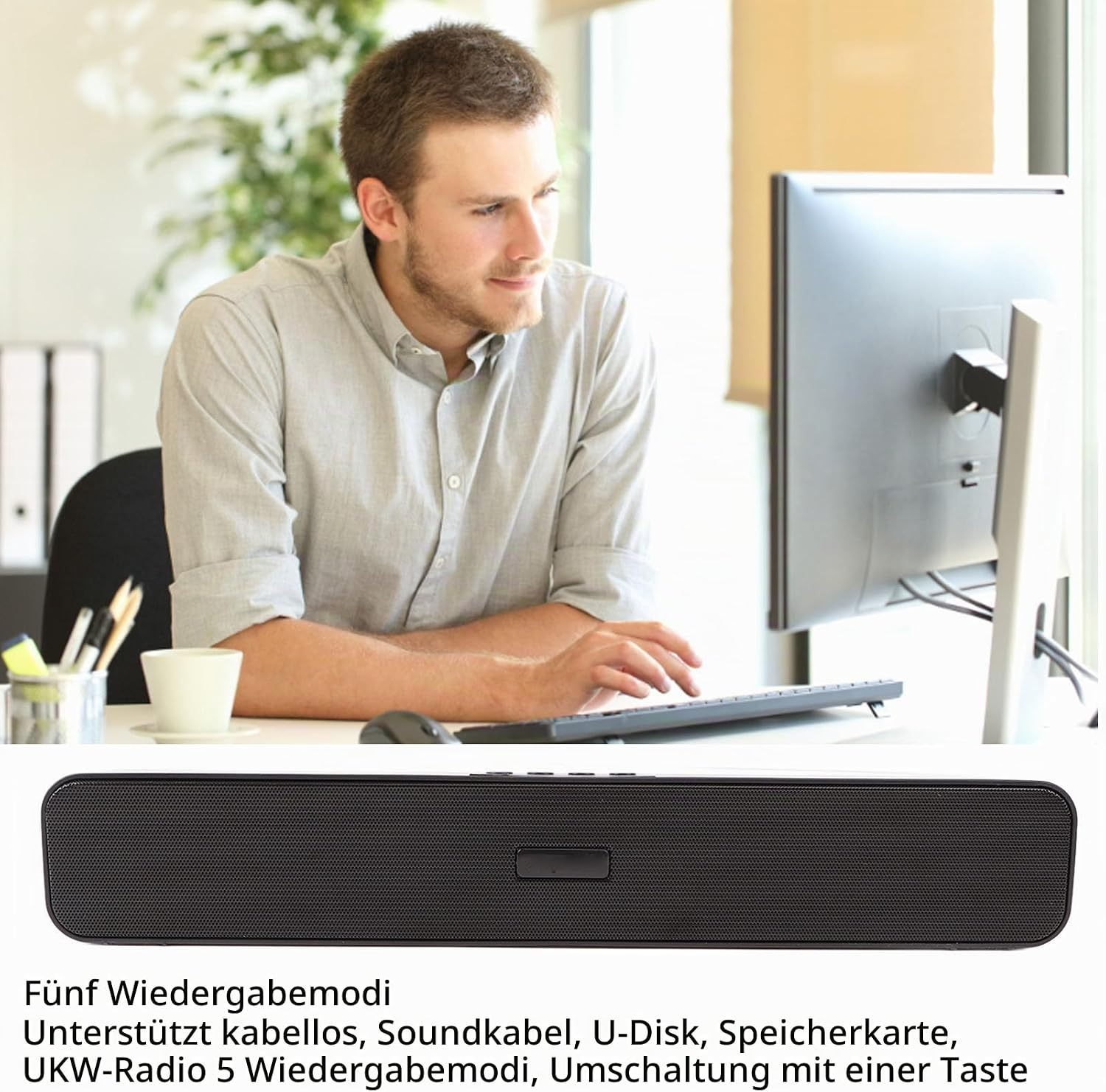 Ein Mann sitzt an einem Computer und tippt, darunter ist ein schwarzer Soundbar mit deutschem Text zu sehen.