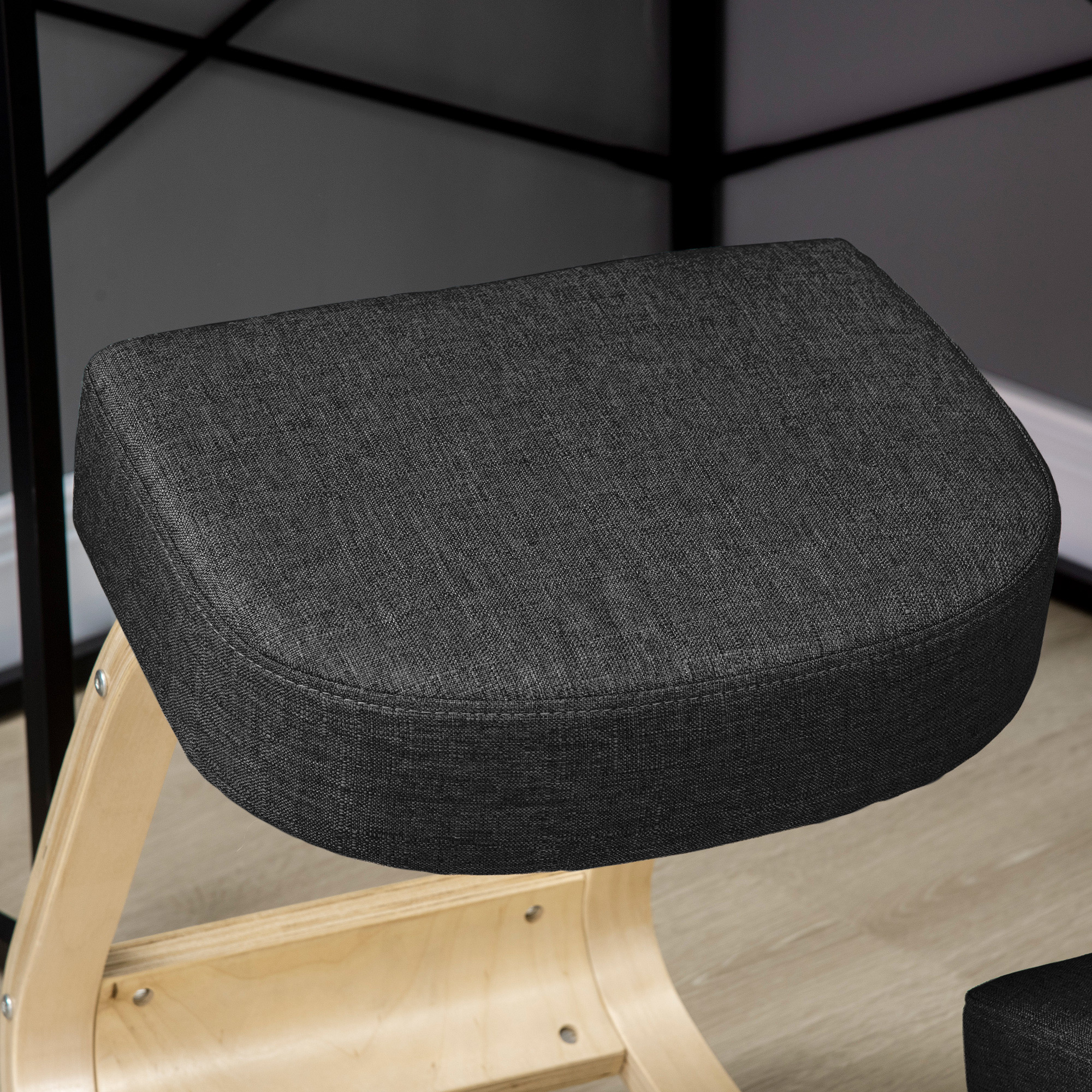Silla ergonómica de rodillas con cojín de tela gris oscuro y estructura de madera clara.