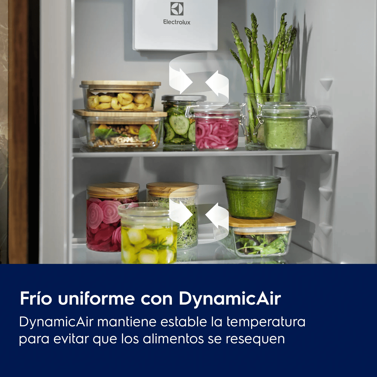 Interior de un refrigerador abierto con varios frascos y recipientes llenos de alimentos frescos.