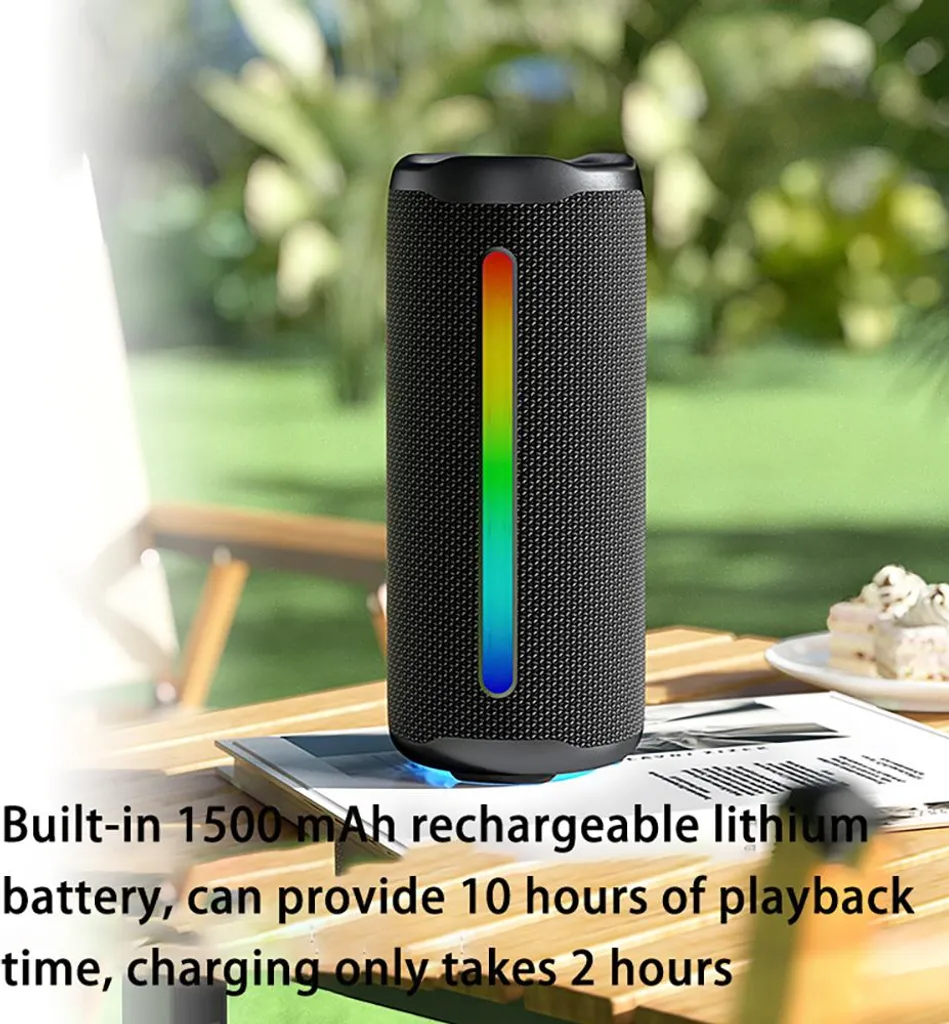 Ein zylindrischer schwarzer Bluetooth-Lautsprecher mit vertikaler RGB-Leiste auf einem Holztisch outdoors.