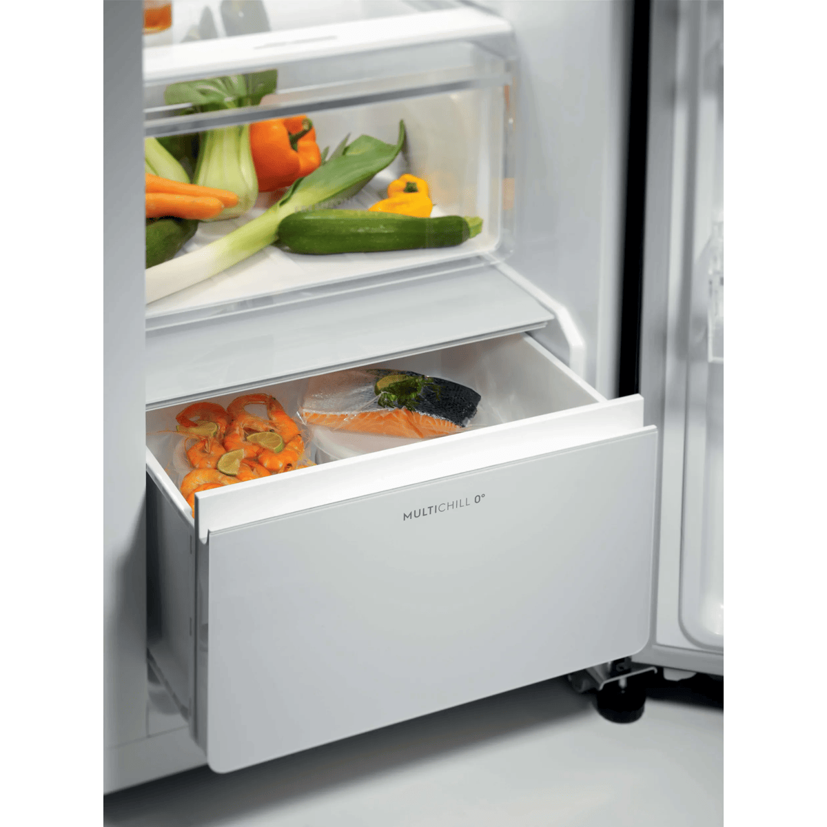 Cajón de refrigerador abierto MULTICHILL 0° con camarones y salmón empaquetados, y verduras arriba.