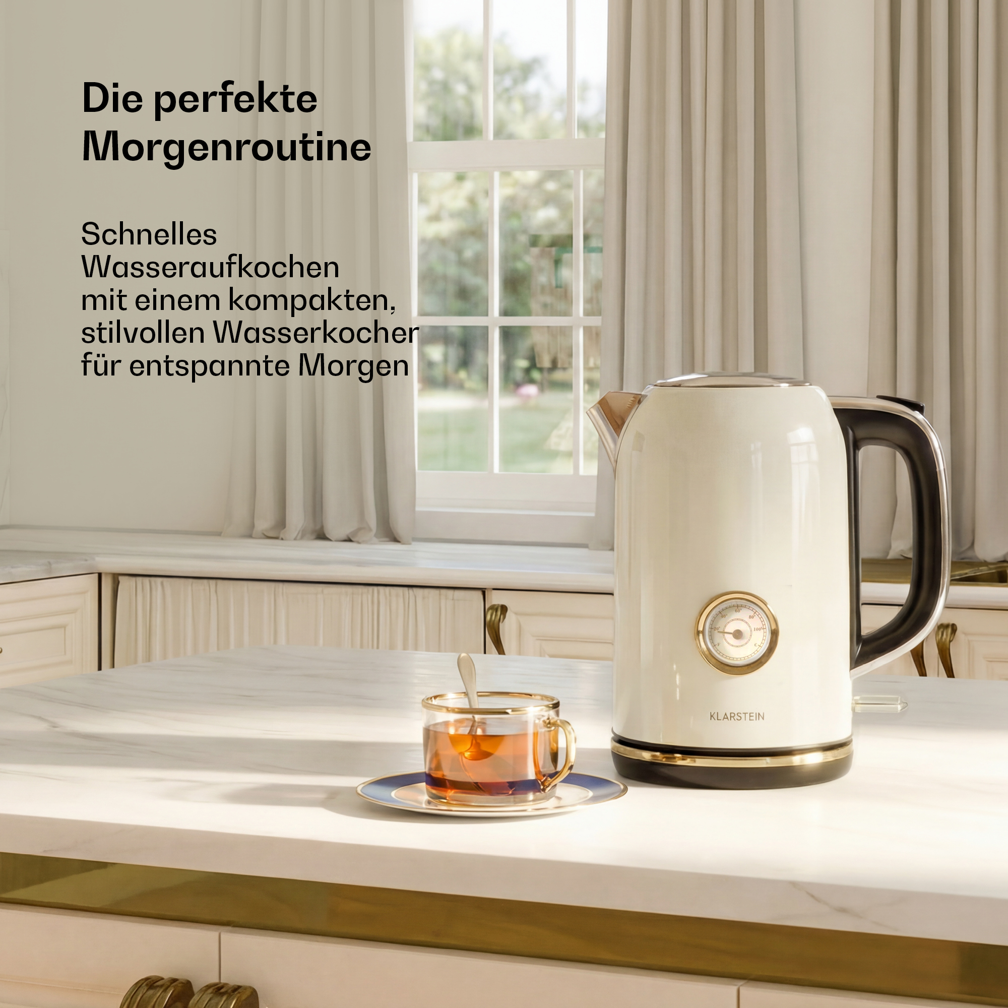 Ein cremefarbener Wasserkocher und eine Tasse Tee stehen auf einer Marmortheke vor einem sonnigen Fenster.