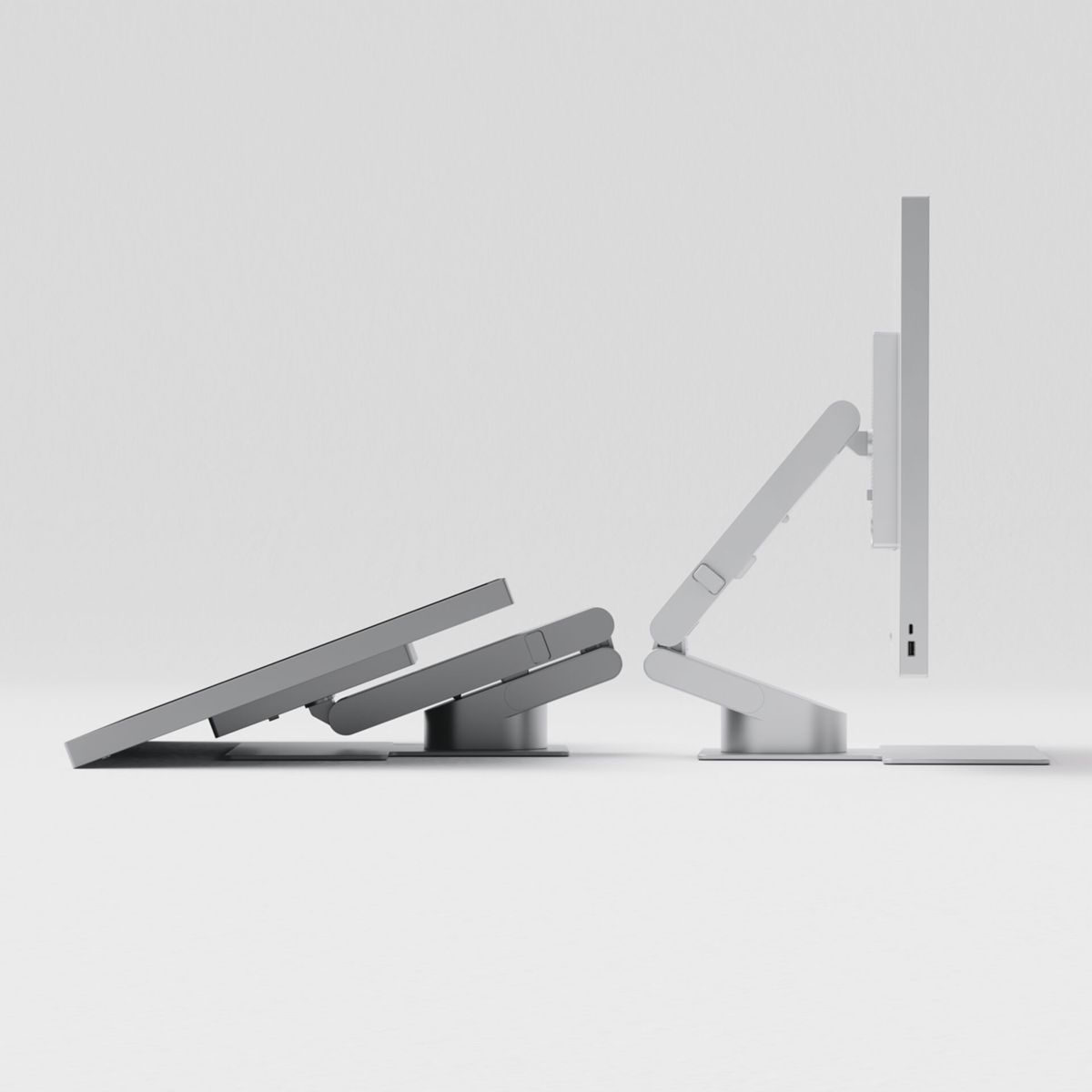 Ein weißer Computerbildschirm auf einem verstellbaren Arm und ein flach gefaltetes Tablet auf einem Ständer.