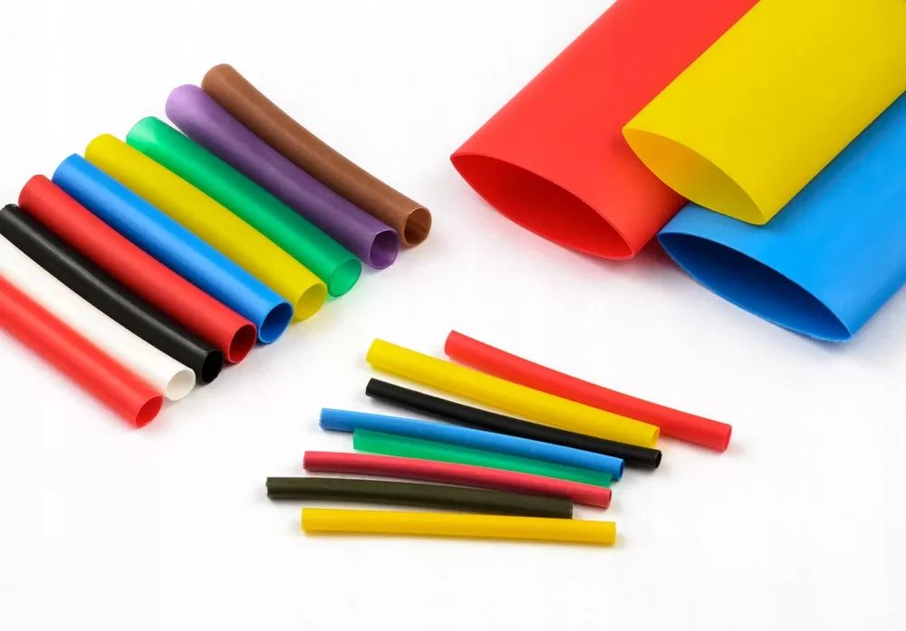 Bunte Schrumpfschläuche in verschiedenen Größen und Farben auf weißem Grund.