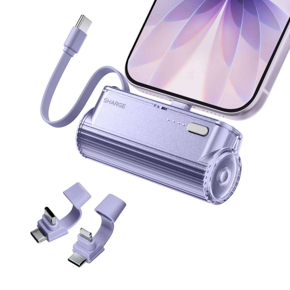 Eine lila Sharge Powerbank eingesteckt in ein Smartphone, mit zwei Adapteraufsätzen in der Nähe auf weißem Grund.