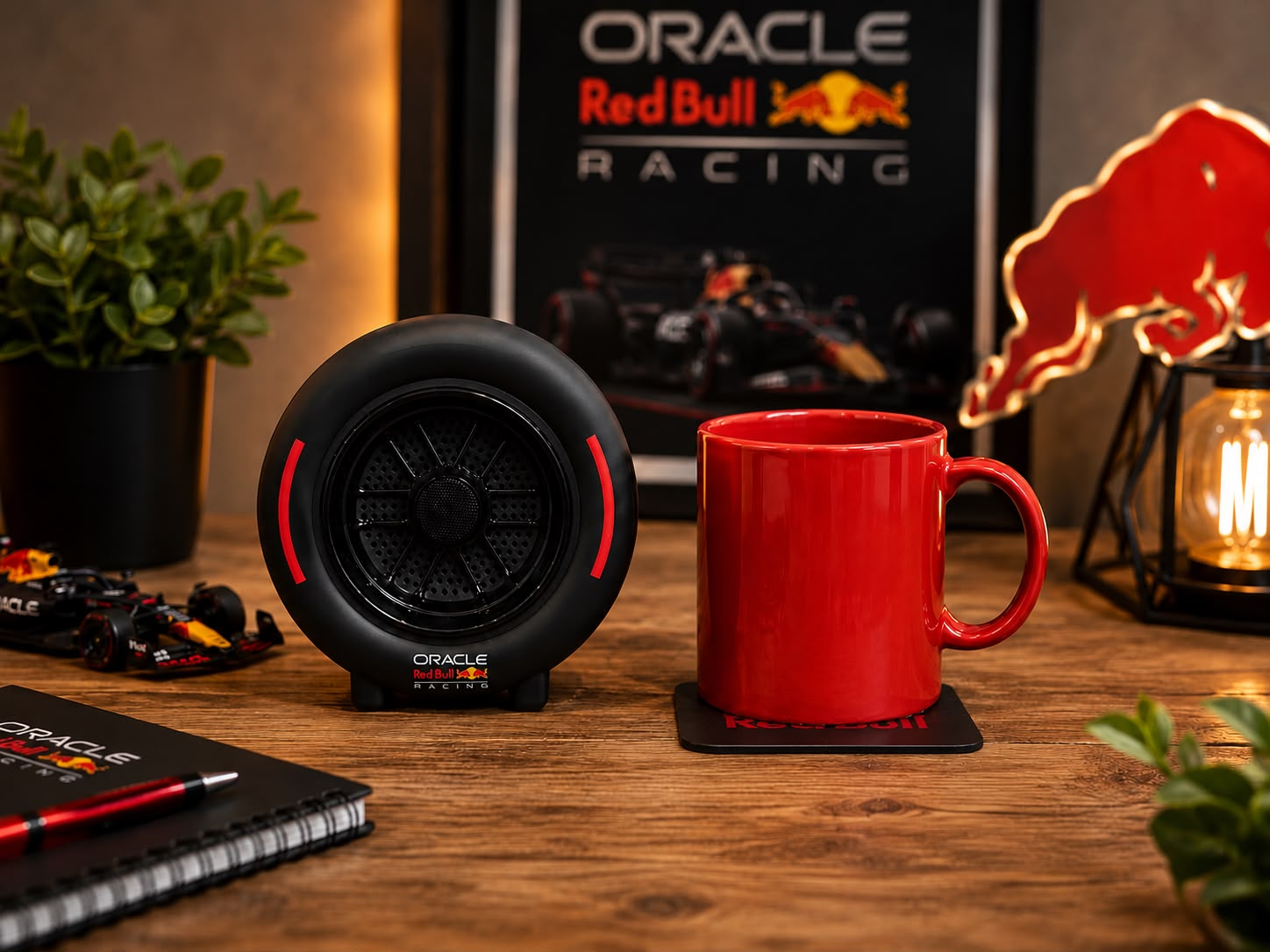 Un altoparlante Red Bull Racing e una tazza rossa su un tavolo di legno, con un poster di F1 sullo sfondo.
