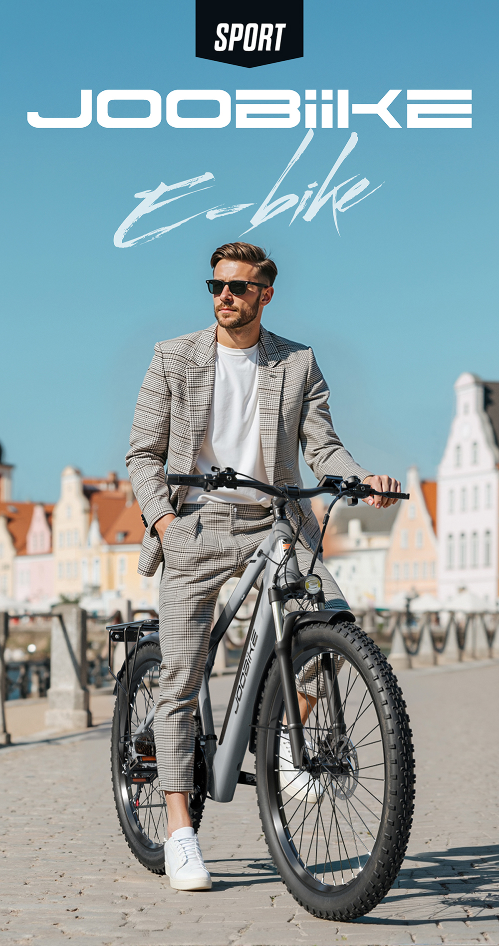 Un uomo elegante in abito a quadri è seduto su una bici elettrica grigia.