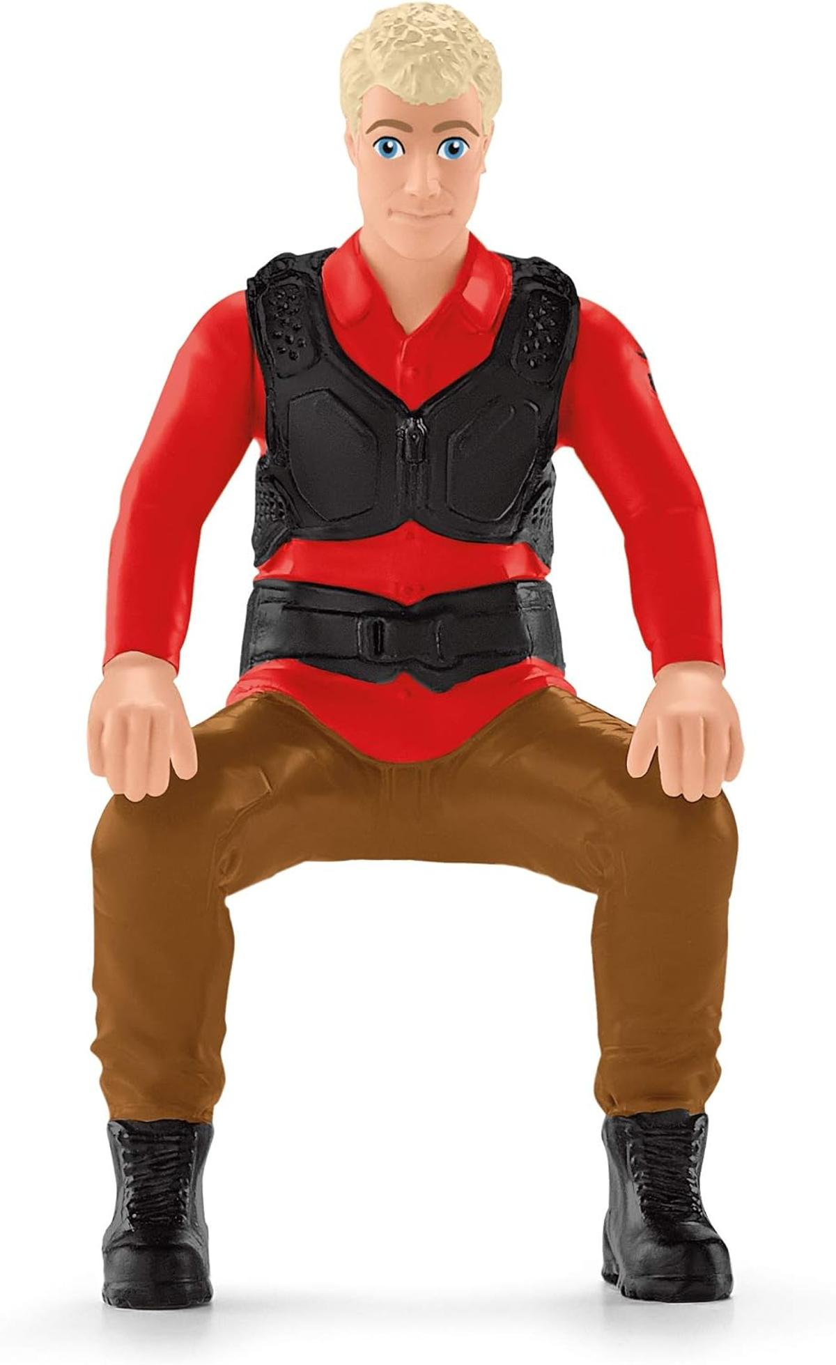 Eine Spielfigur eines Mannes mit blondem Haar, rotem Hemd, schwarzer Weste und braunen Hosen auf weißem Hintergrund.