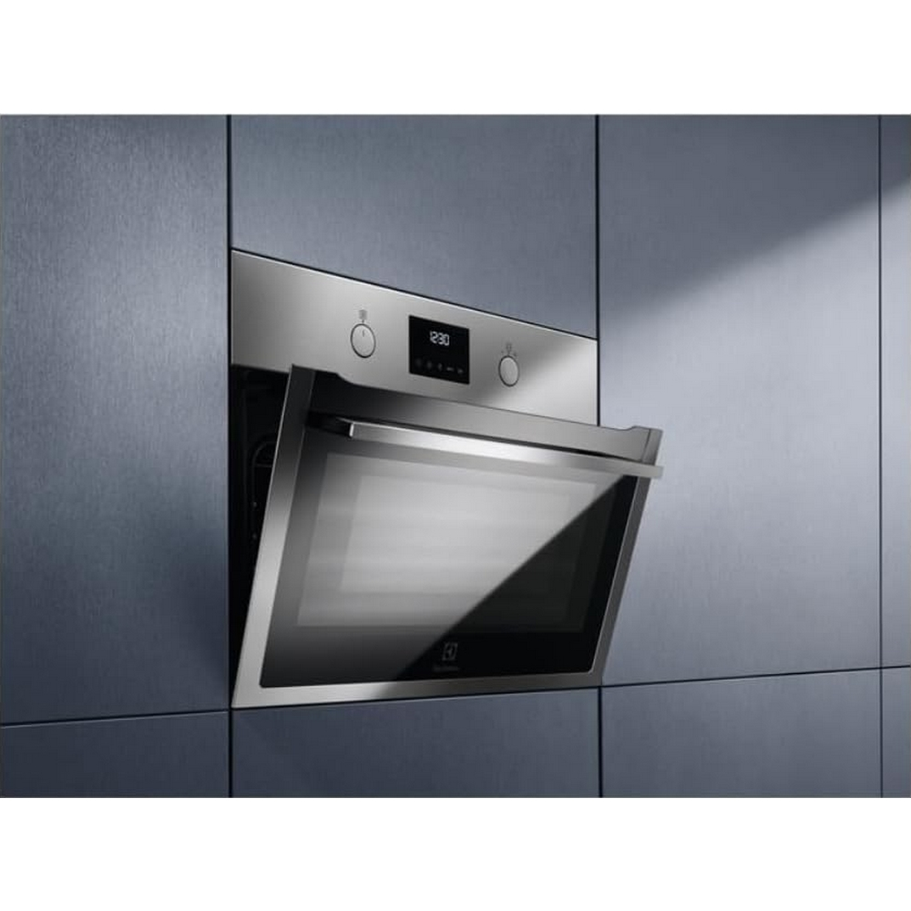 Un forno da incasso in acciaio inossidabile con porta in vetro leggermente aperta inserito in una parete blu.