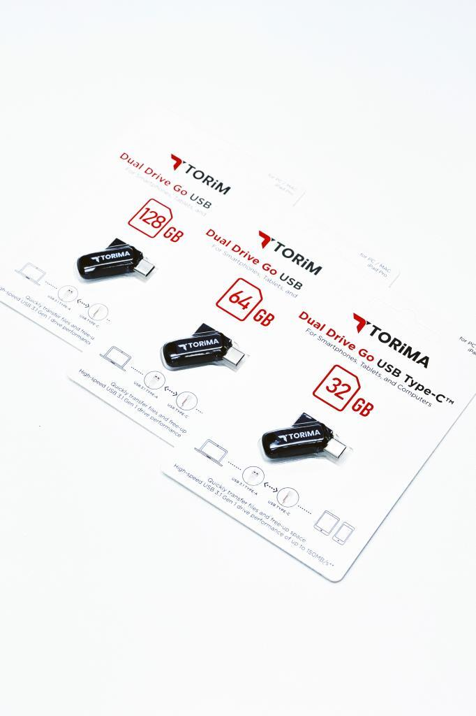 Beyaz ambalaj üzerinde 32GB, 64GB ve 128GB kapasitelerinde üç Torim çift taraflı USB bellek.