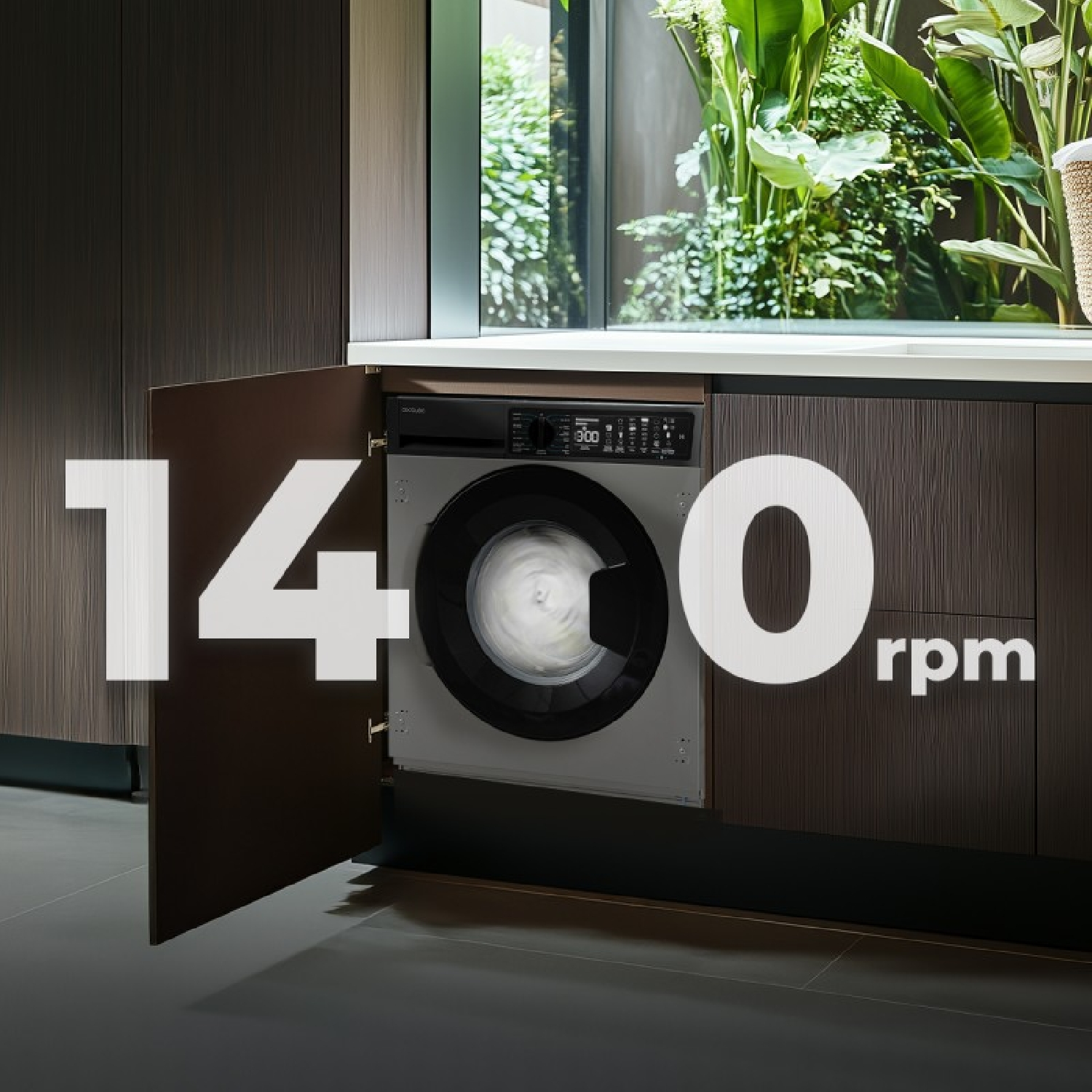 Una lavadora empotrada a 1400 rpm en una cocina moderna con vista a plantas verdes.