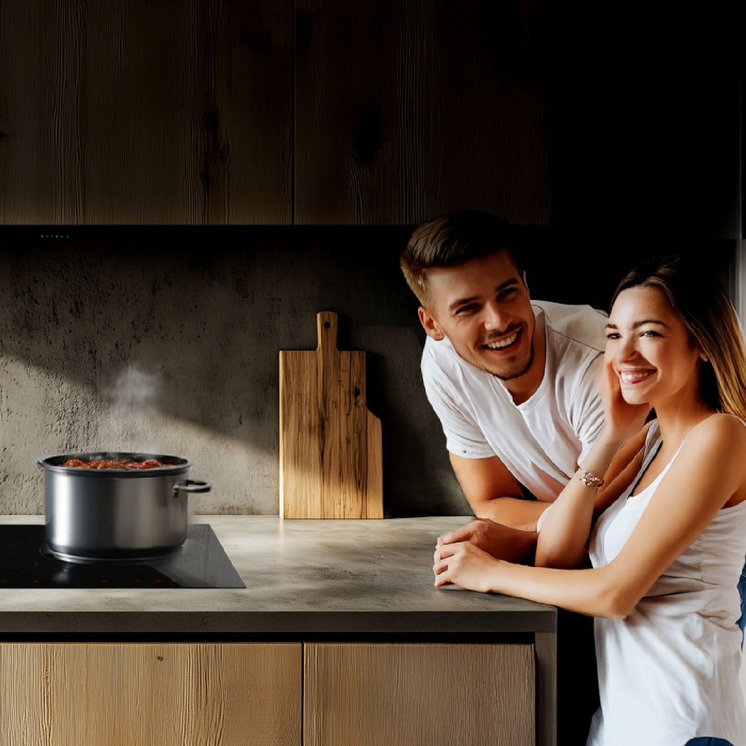 Una pareja sonriente se apoya en una encimera junto a una olla humeante en la estufa y una tabla de cortar.