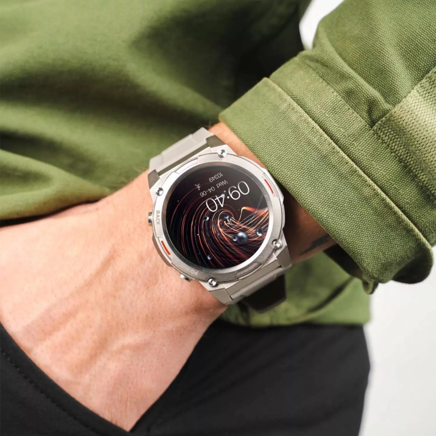 Osoba nosząca szary smartwatch z abstrakcyjną, falistą tarczą na nadgarstku.