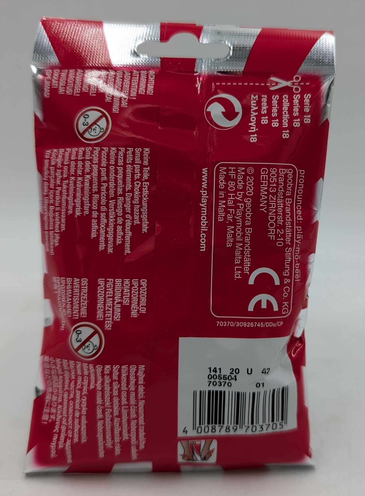 Rückseite einer roten Playmobil-Verpackung mit Sicherheitshinweisen in verschiedenen Sprachen und einem Barcode unten.