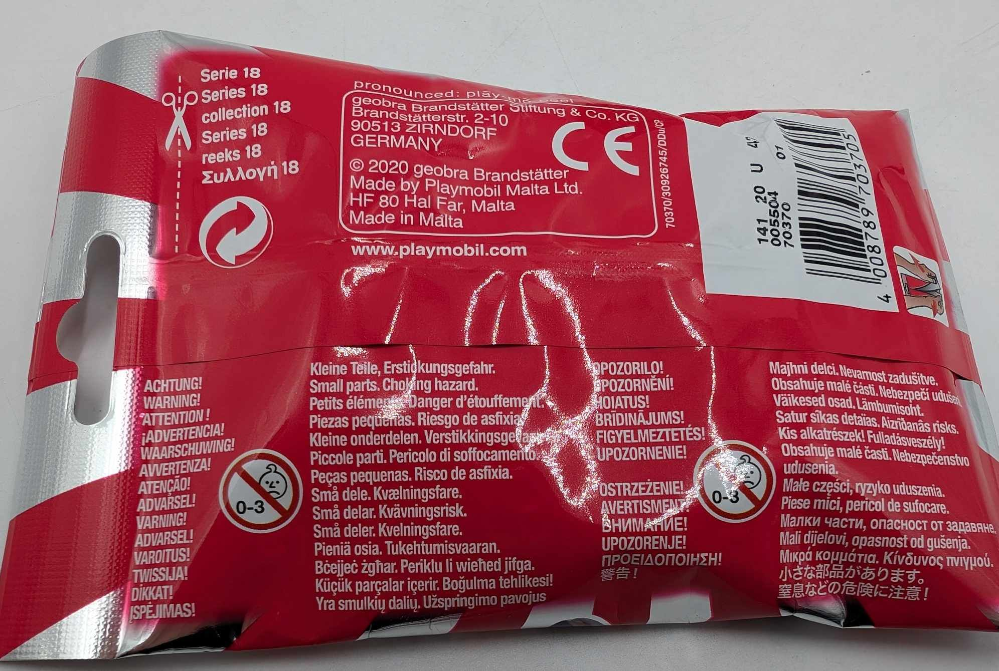 Rückseite einer roten Playmobil-Verpackung mit Warntexten in vielen Sprachen und Barcode.