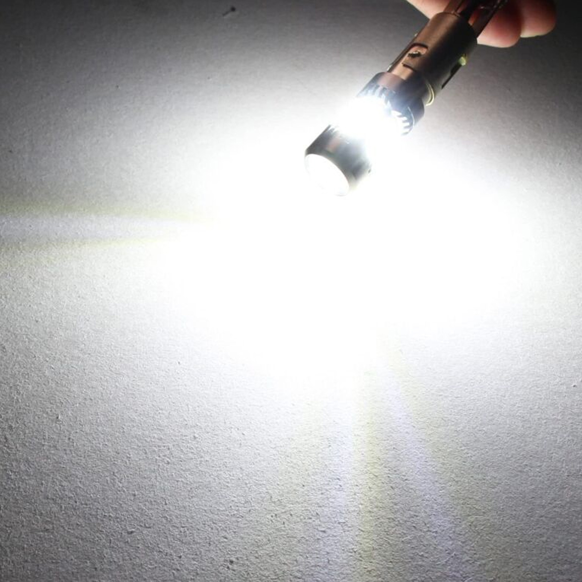 Eine helle weiße LED-Glühbirne wird gehalten und wirft einen starken Lichtstrahl auf eine Oberfläche.
