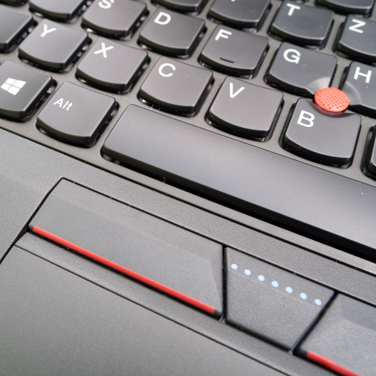 Nahaufnahme einer Laptop-Tastatur mit schwarzen Tasten, der Leertaste und einem Touchpad mit roten Linien.