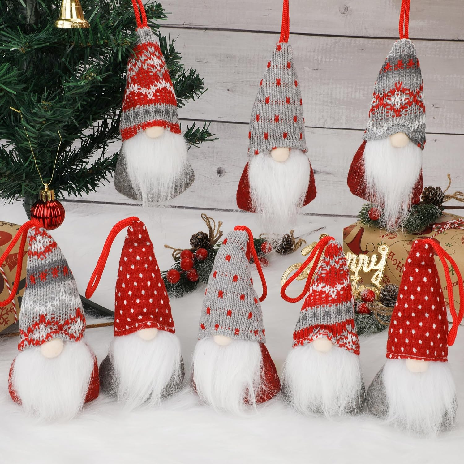 Neun süße Plüsch-Weihnachtswichtel mit hohen Mützen und langen weißen Bärten stehen vor einer rustikalen Holzwand.