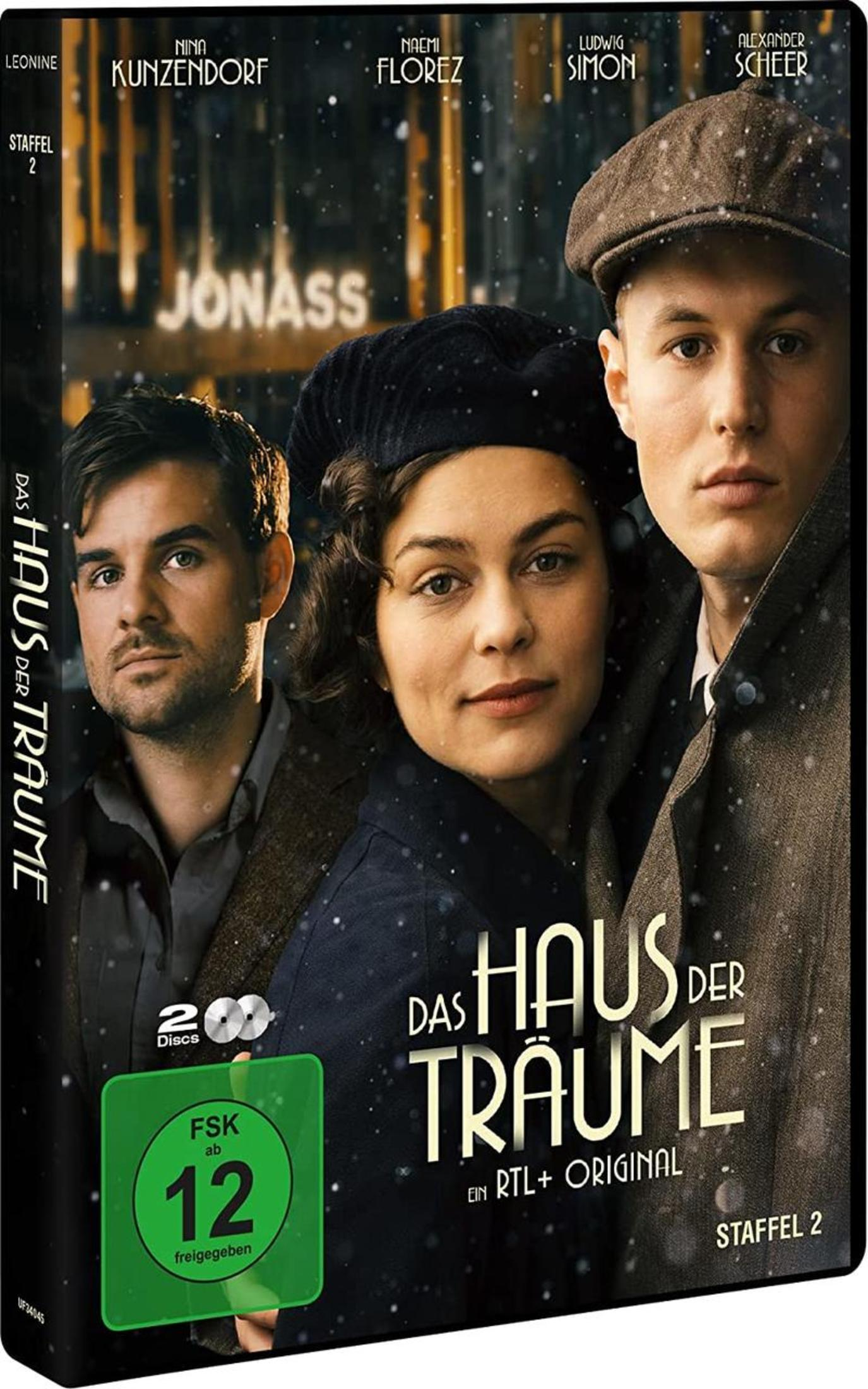 DVD-Cover von 'Das Haus der Träume Staffel 2' mit drei Personen vor einer beleuchteten Kulisse im Schnee.