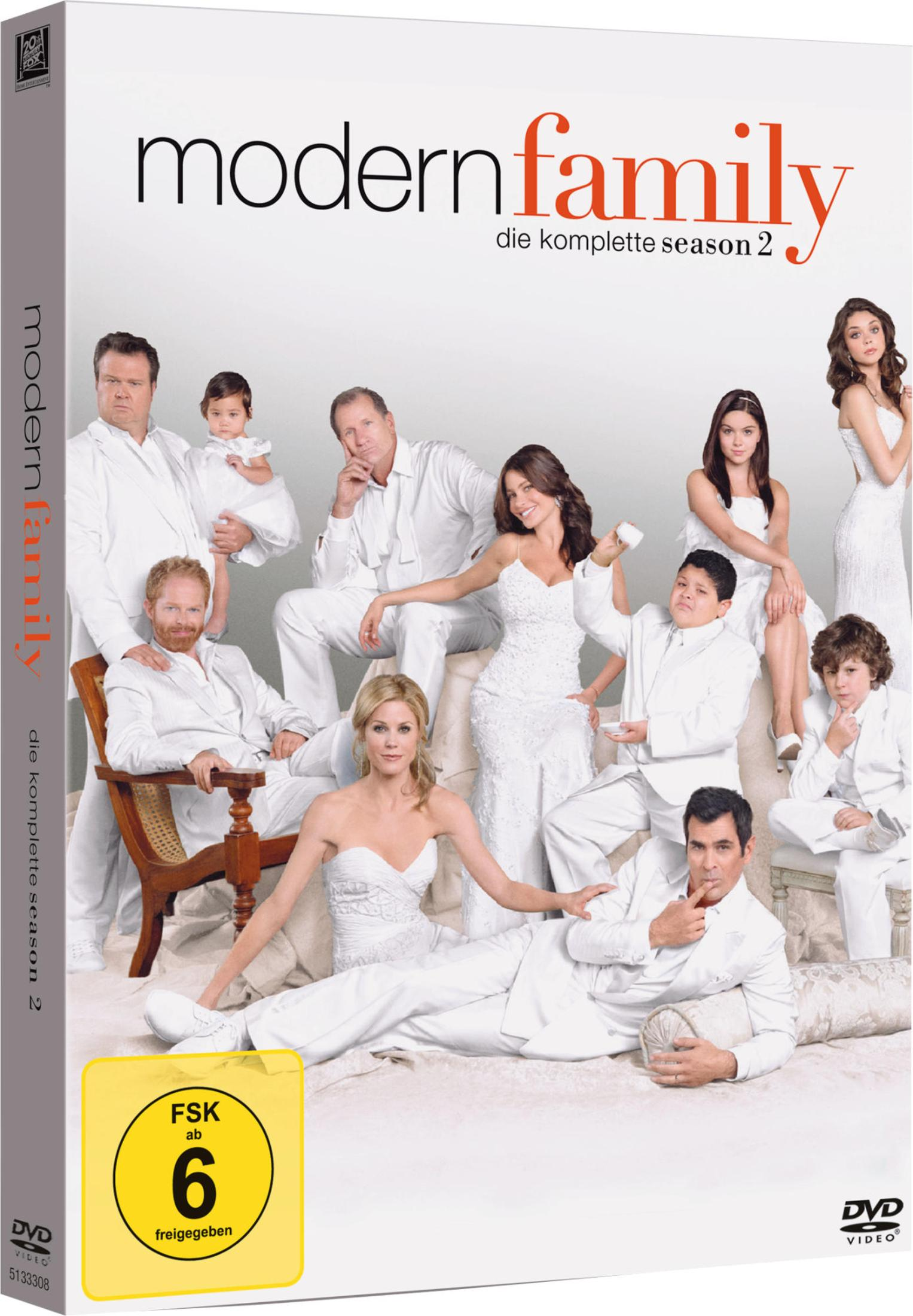 Das Cast von Modern Family posiert in weißen Outfits vor weißem Hintergrund.