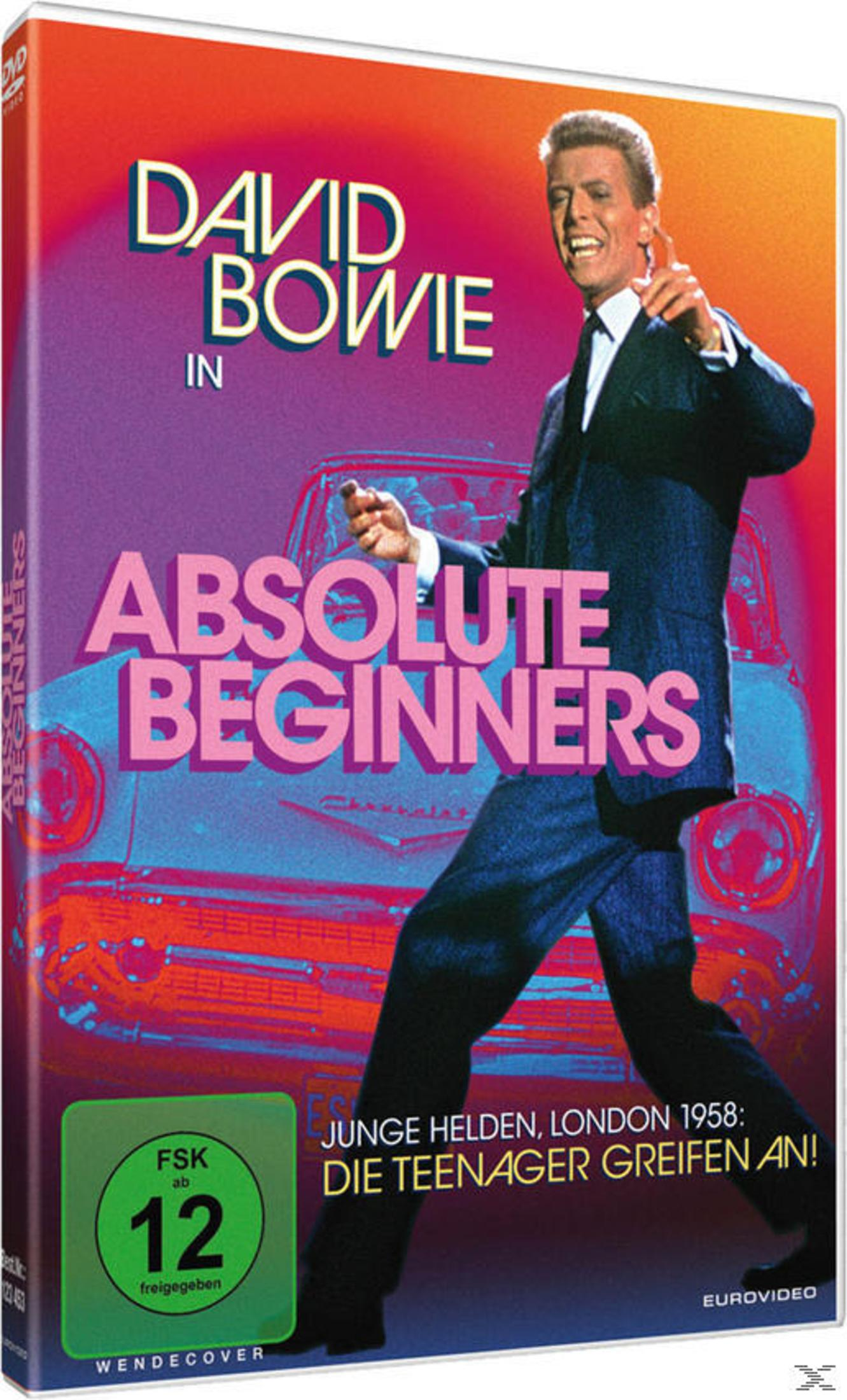 David Bowie im Anzug tanzt vor einem Auto auf dem DVD-Cover von Absolute Beginners mit FSK-12-Logo.