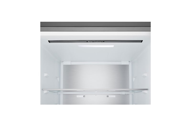 Interior de un refrigerador moderno vacío con paredes blancas, panel trasero de metal y un estante de vidrio.