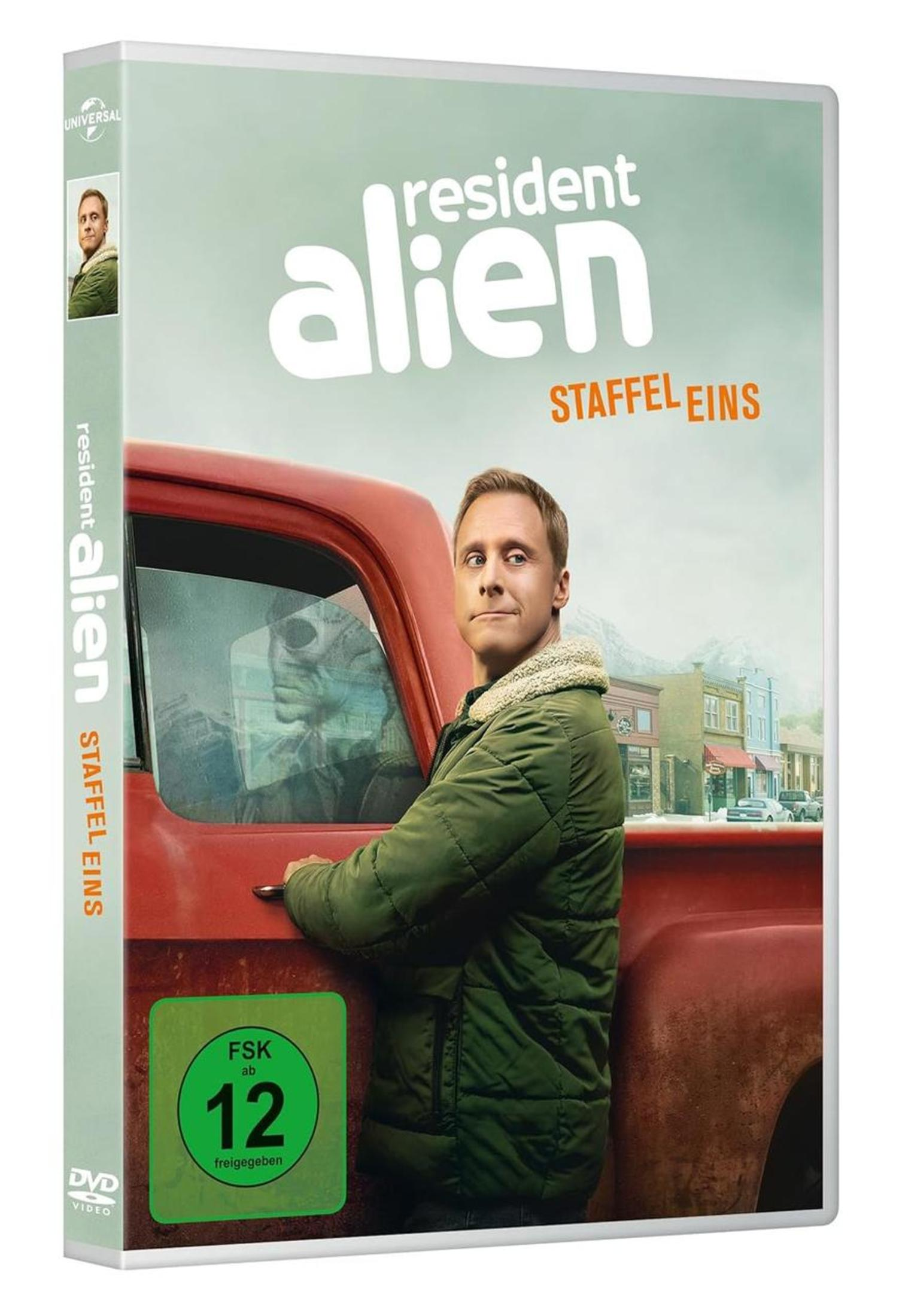 DVD-Cover von Resident Alien Staffel 1 mit einem Mann in grüner Jacke vor rotem Pick-up.