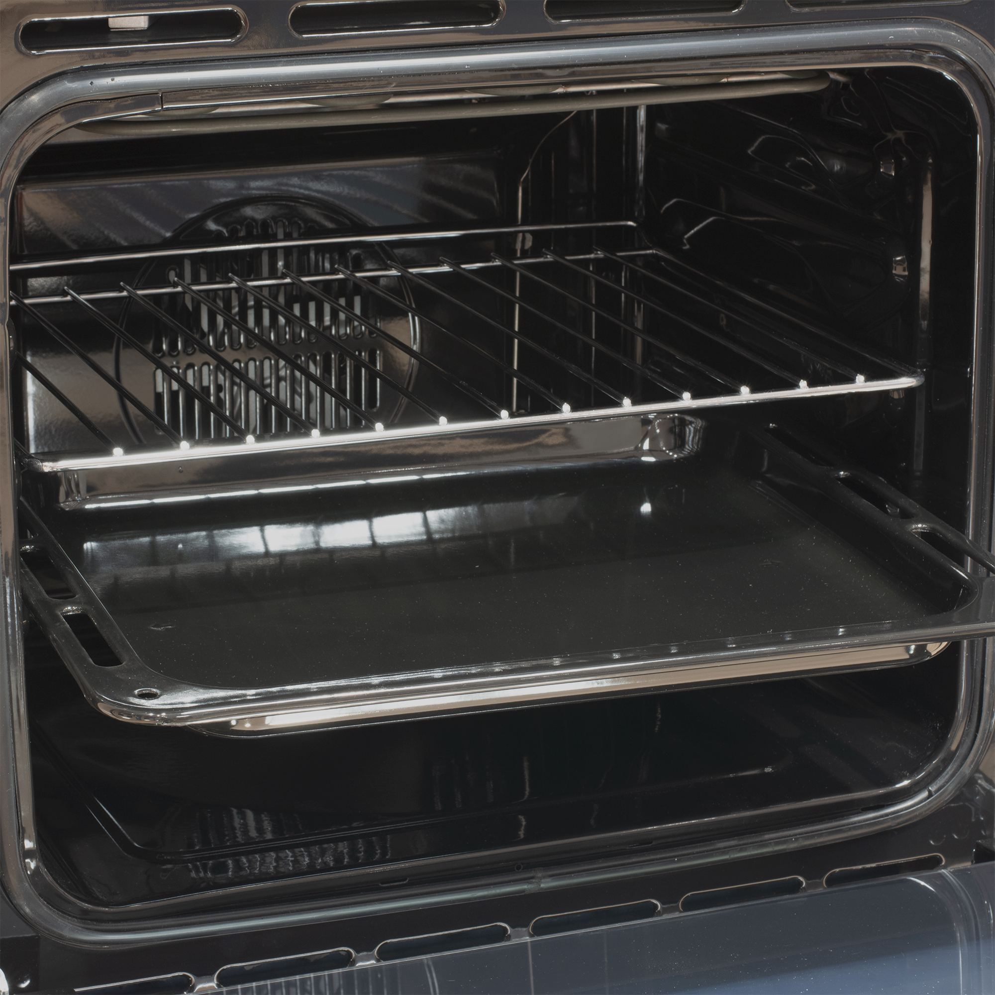 Interior de un horno negro abierto con una rejilla y una bandeja.