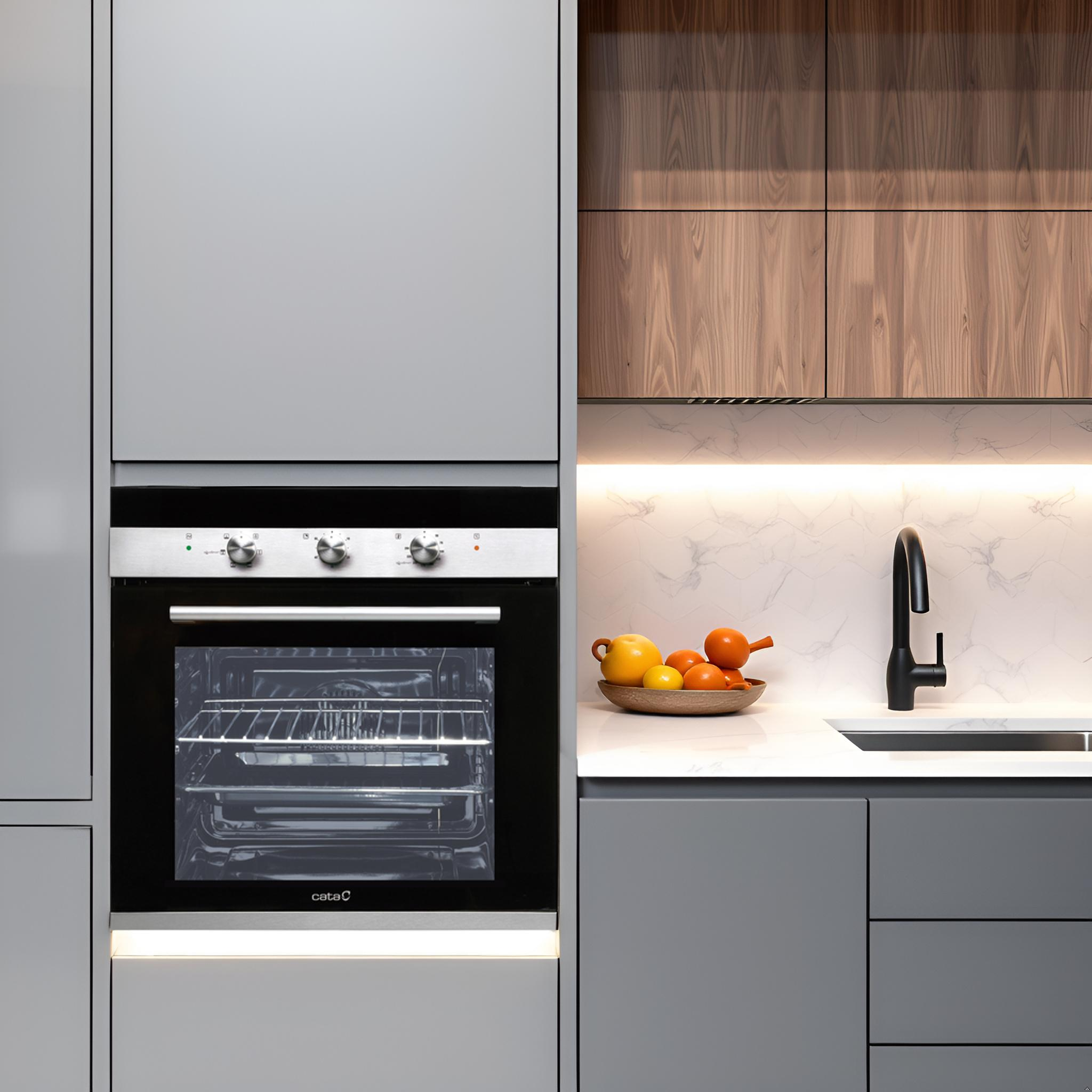 Cocina moderna con horno empotrado, gabinetes grises, detalles en madera y un frutero en la encimera.