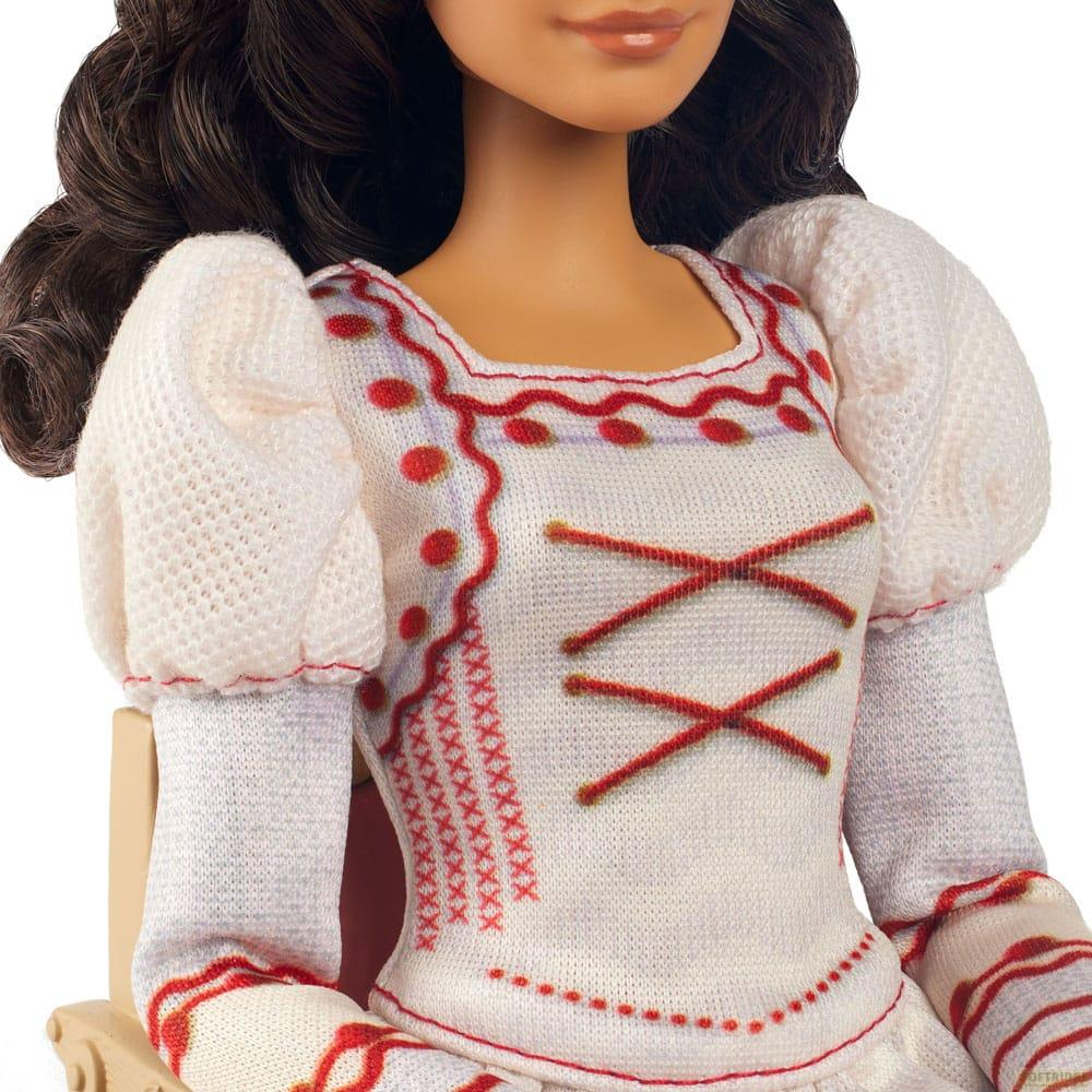 Nahaufnahme einer Puppe in einem weißen Kleid mit roten Akzenten, gepufften Ärmeln und dunkelbraunem Haar.