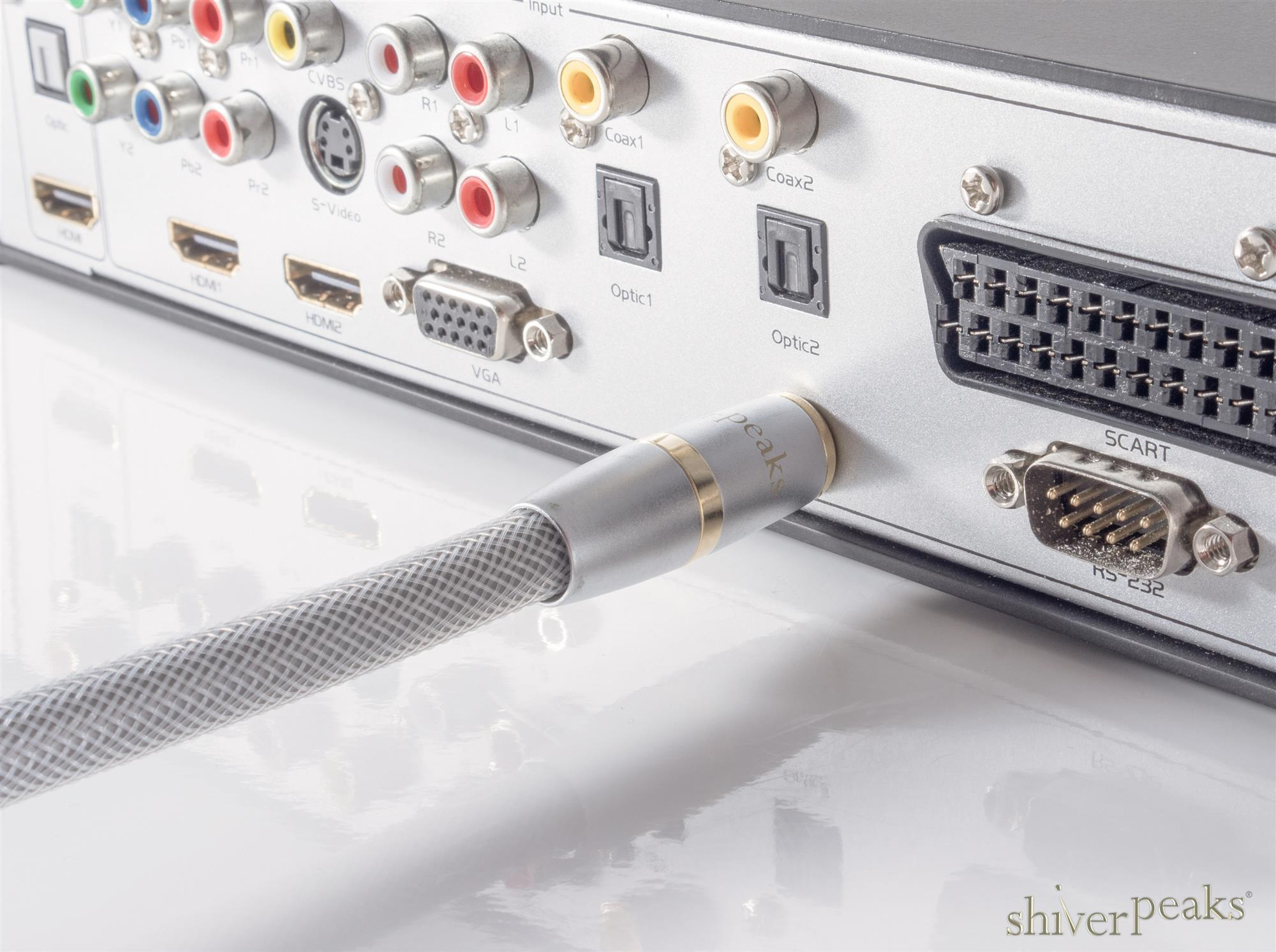 Ein silbernes Audiokabel mit Geflecht steckt in der Rückseite eines Elektronikgeräts.