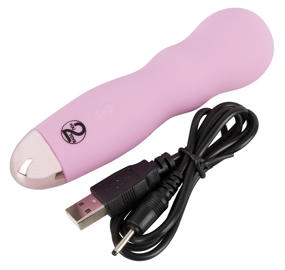 Ein rosafarbenes, ergonomisches Massagegerät mit silberner Kappe und einem schwarzen USB-Ladekabel auf weißem Grund.