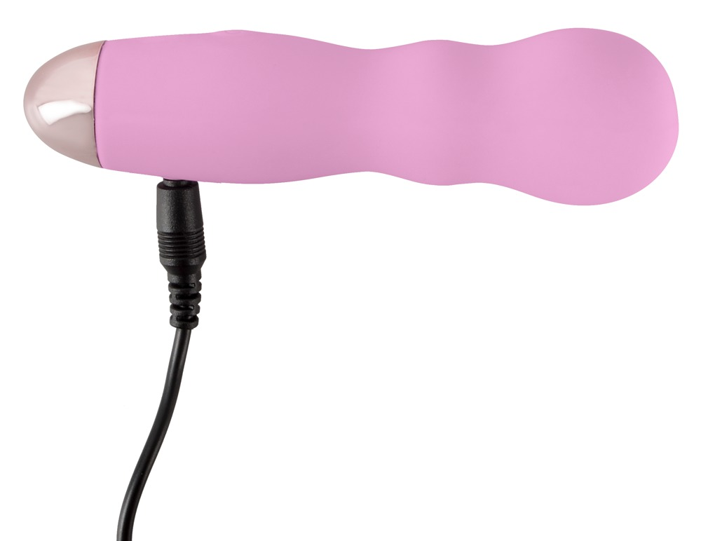 Ein rosafarbener, wellenförmiger Vibrator mit silberner Kappe und angeschlossenem schwarzen Ladekabel vor weißem Hintergrund.