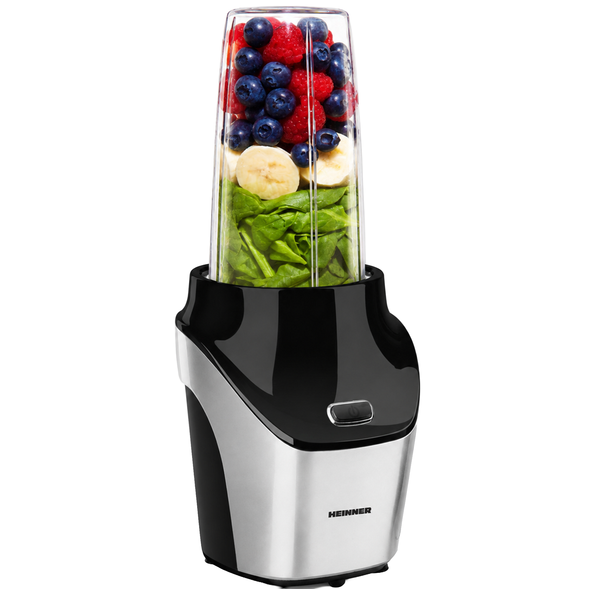 Ein schwarzer Standmixer gefüllt mit grünem Spinat, Bananen, Blaubeeren und Himbeeren.