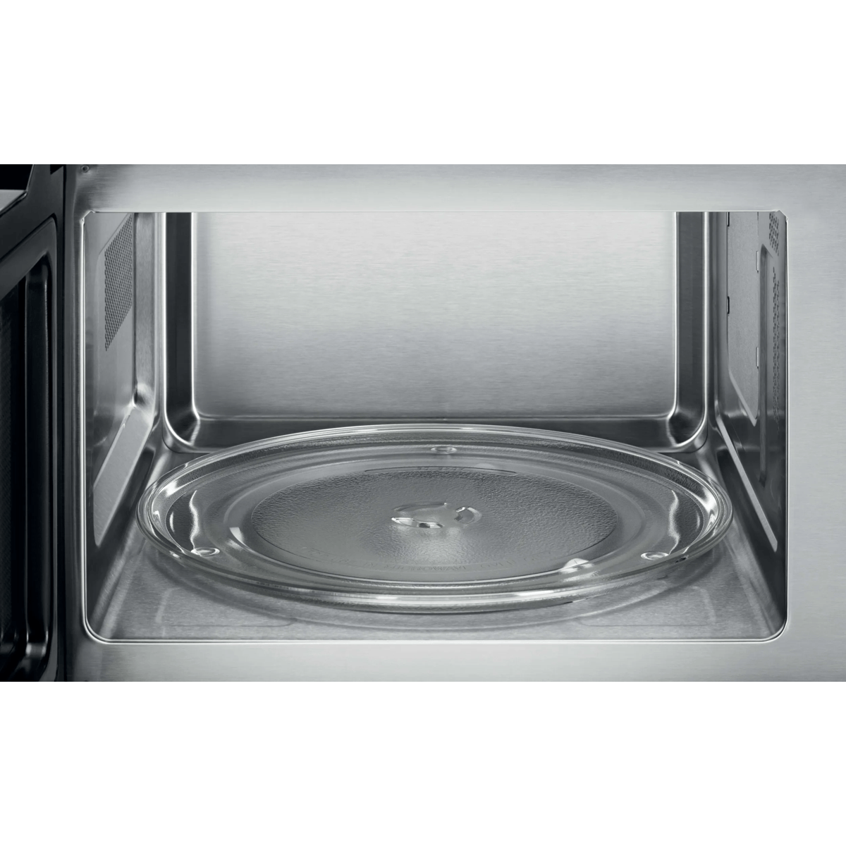 El interior de un horno microondas vacío con un plato de vidrio giratorio.