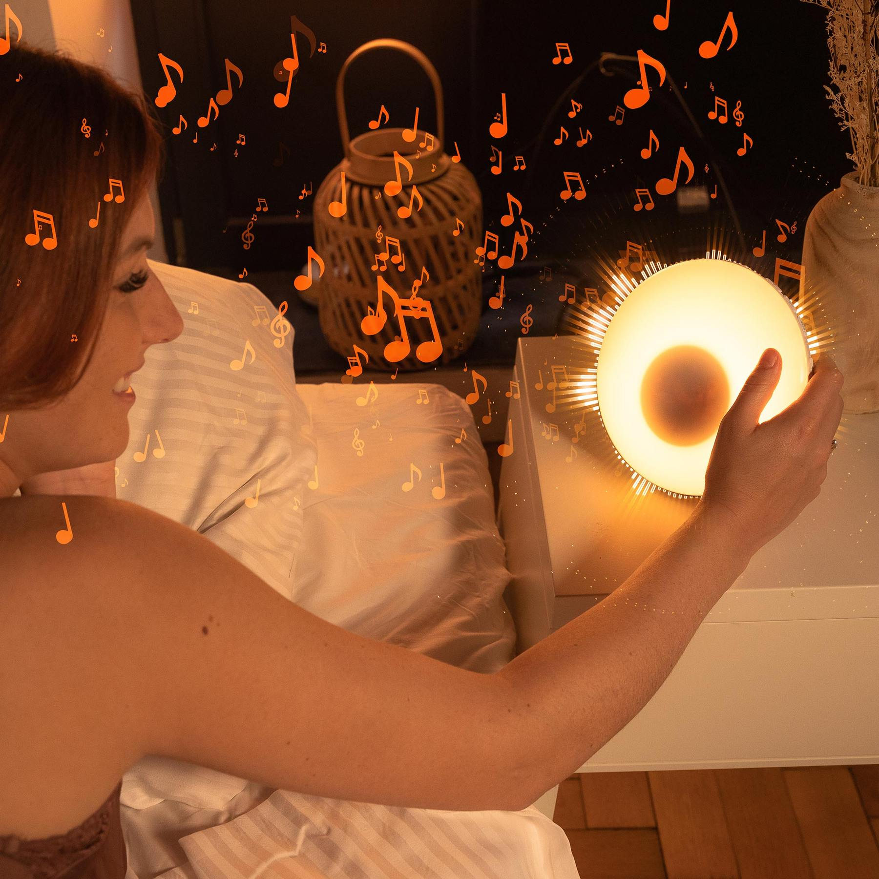 A woman in bed touches a glowing bedside lamp, surrounded by floating orange musical notes.